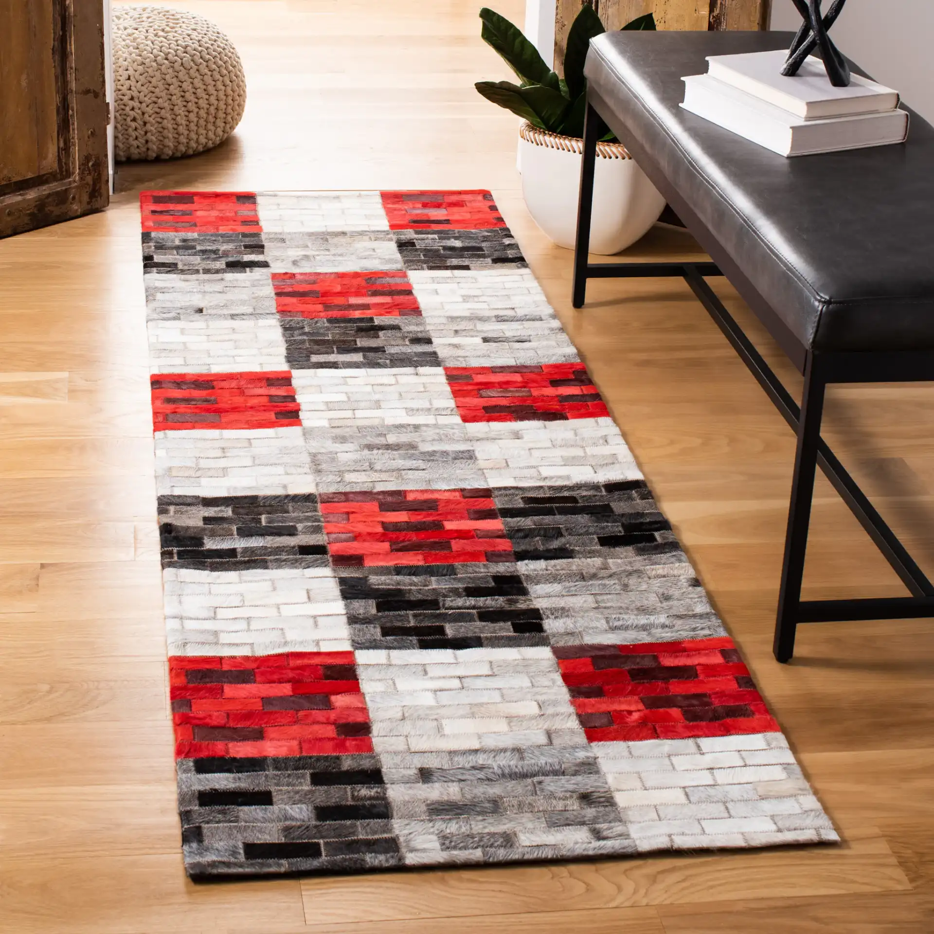 Studio Leather Checkerboard Patchwork Hand-Woven Rug in Gray / Red in a styled room