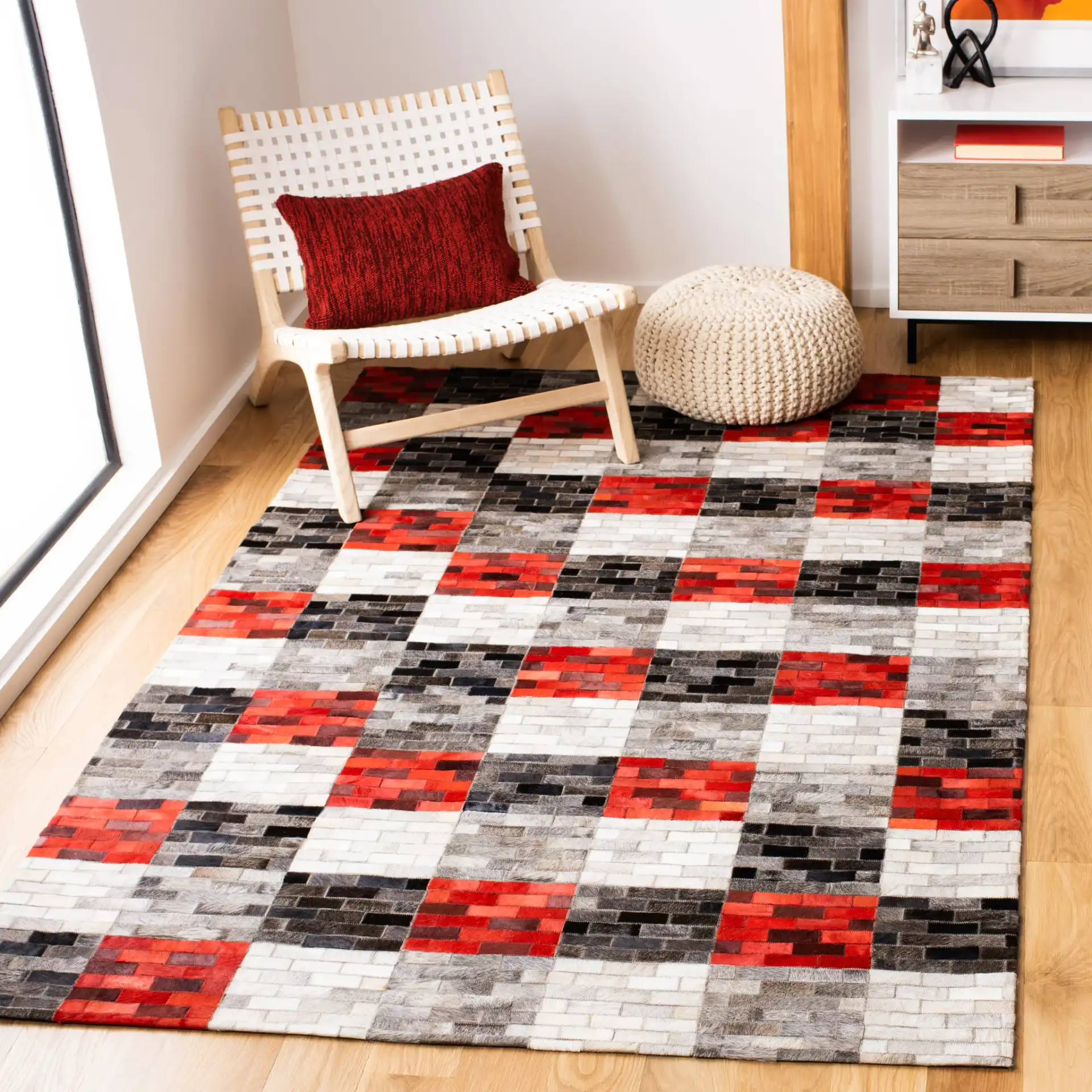 Studio Leather Checkerboard Patchwork Hand-Woven Rug in Gray / Red in a styled room
