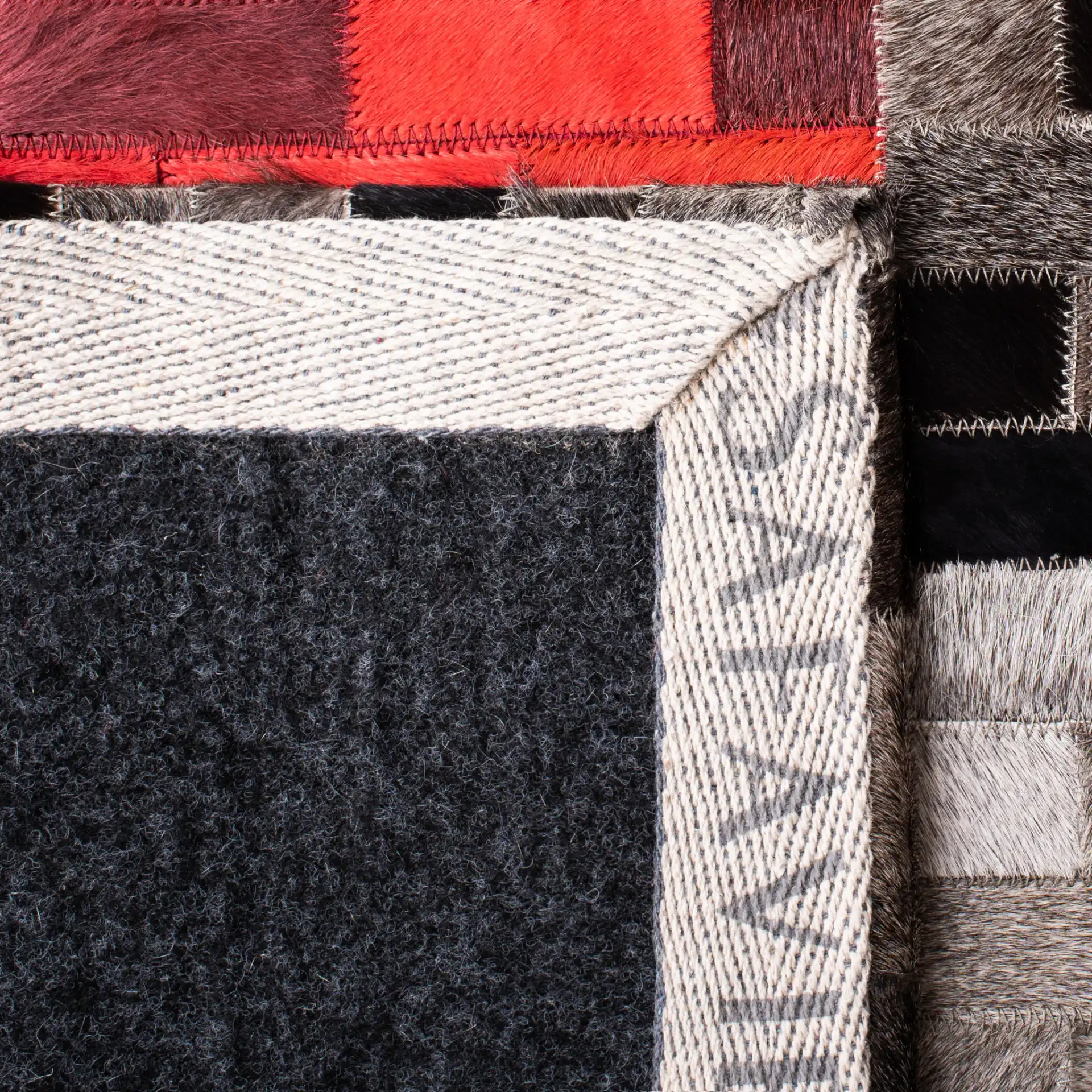Studio Leather Checkerboard Patchwork Hand-Woven Rug in Gray / Red in a styled room
