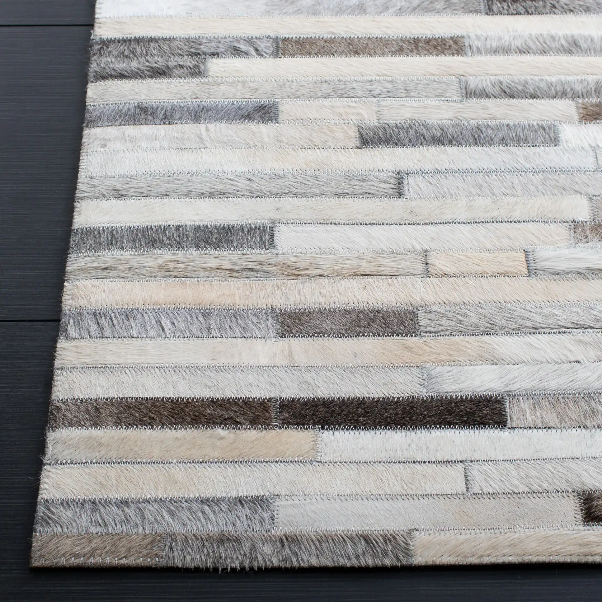 Studio Leather Brick Patchwork Hand-Woven Rug in Ivory / Gray in a styled room