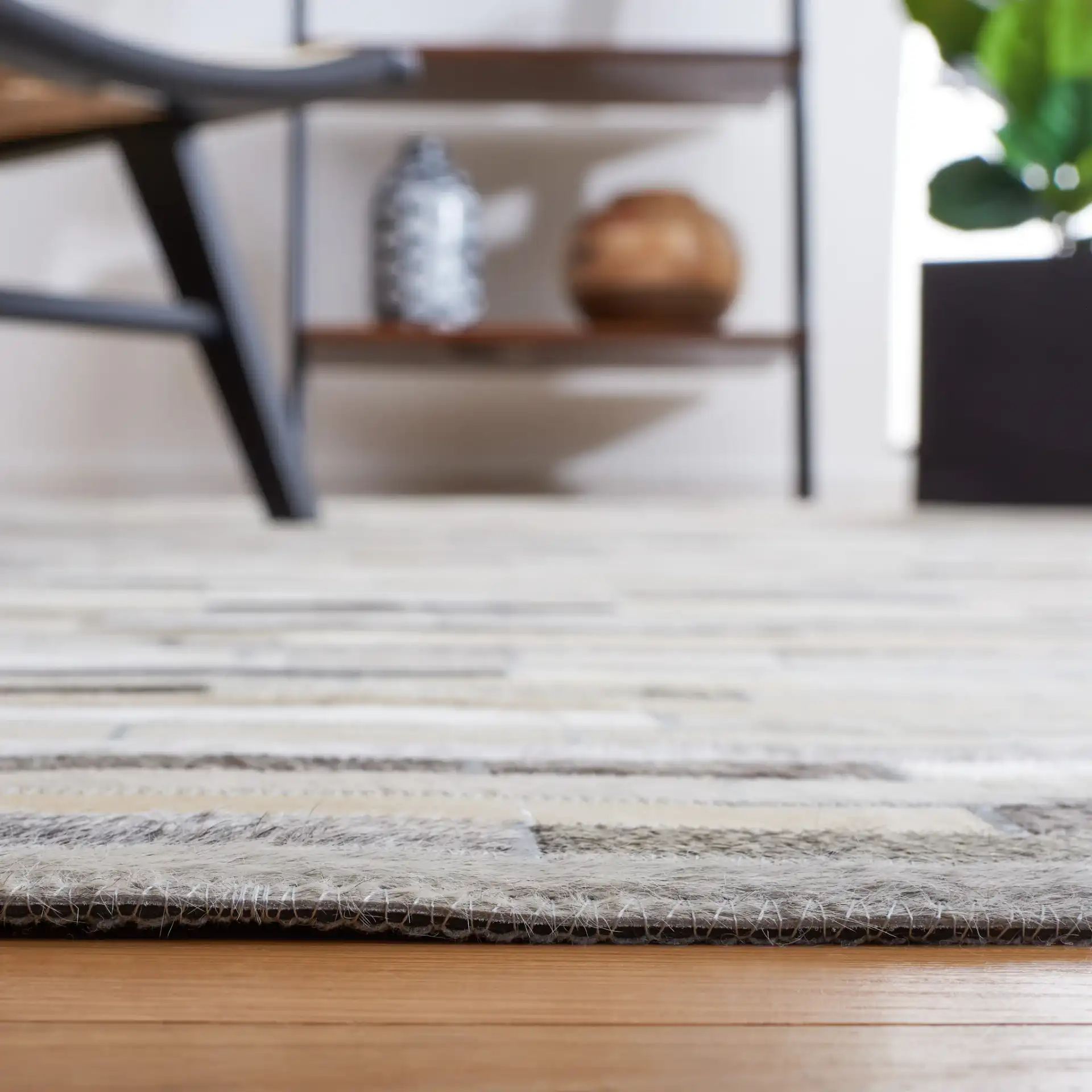 Studio Leather Brick Patchwork Hand-Woven Rug in Ivory / Gray in a styled room