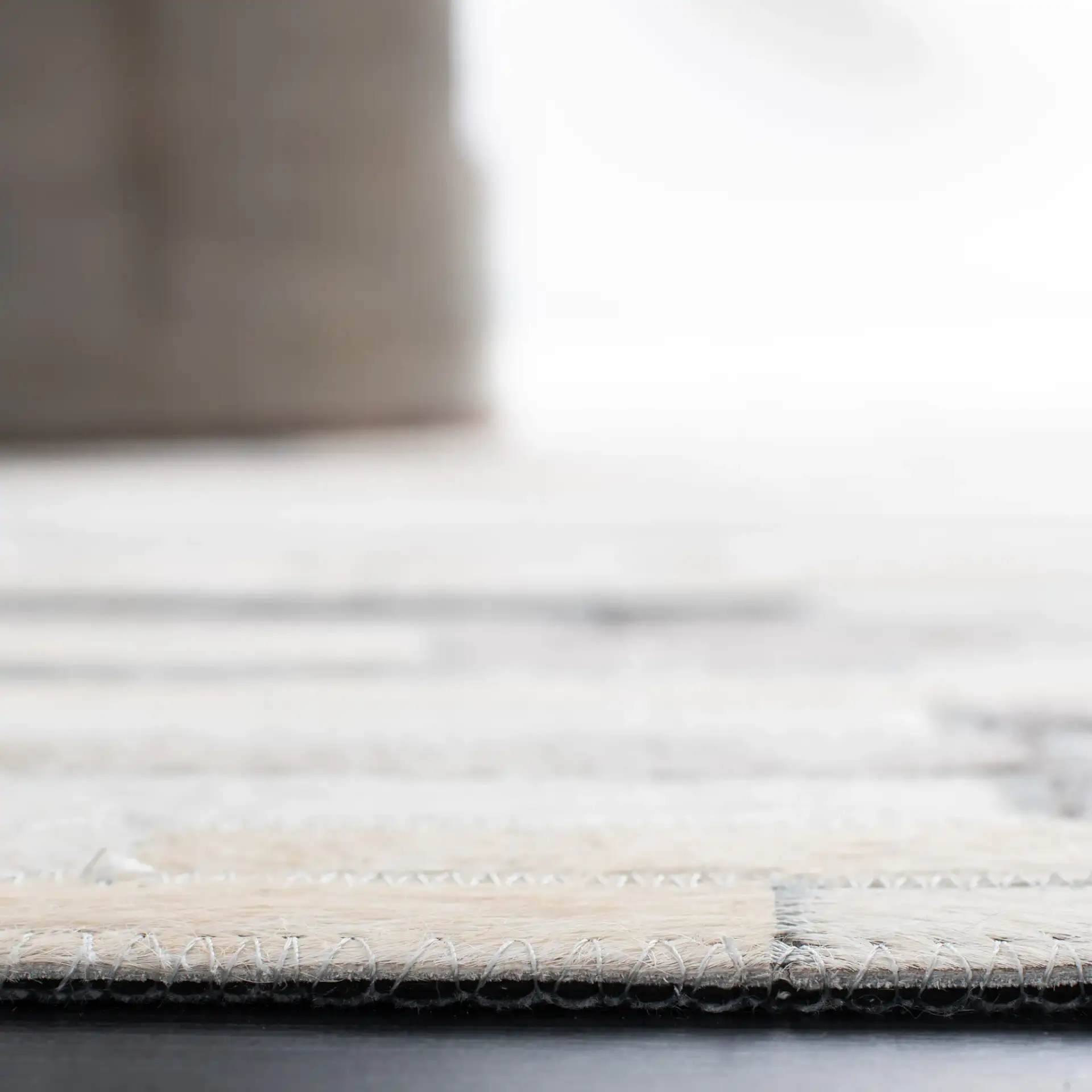 Studio Leather Brick Patchwork Hand-Woven Rug in Ivory / Gray in a styled room