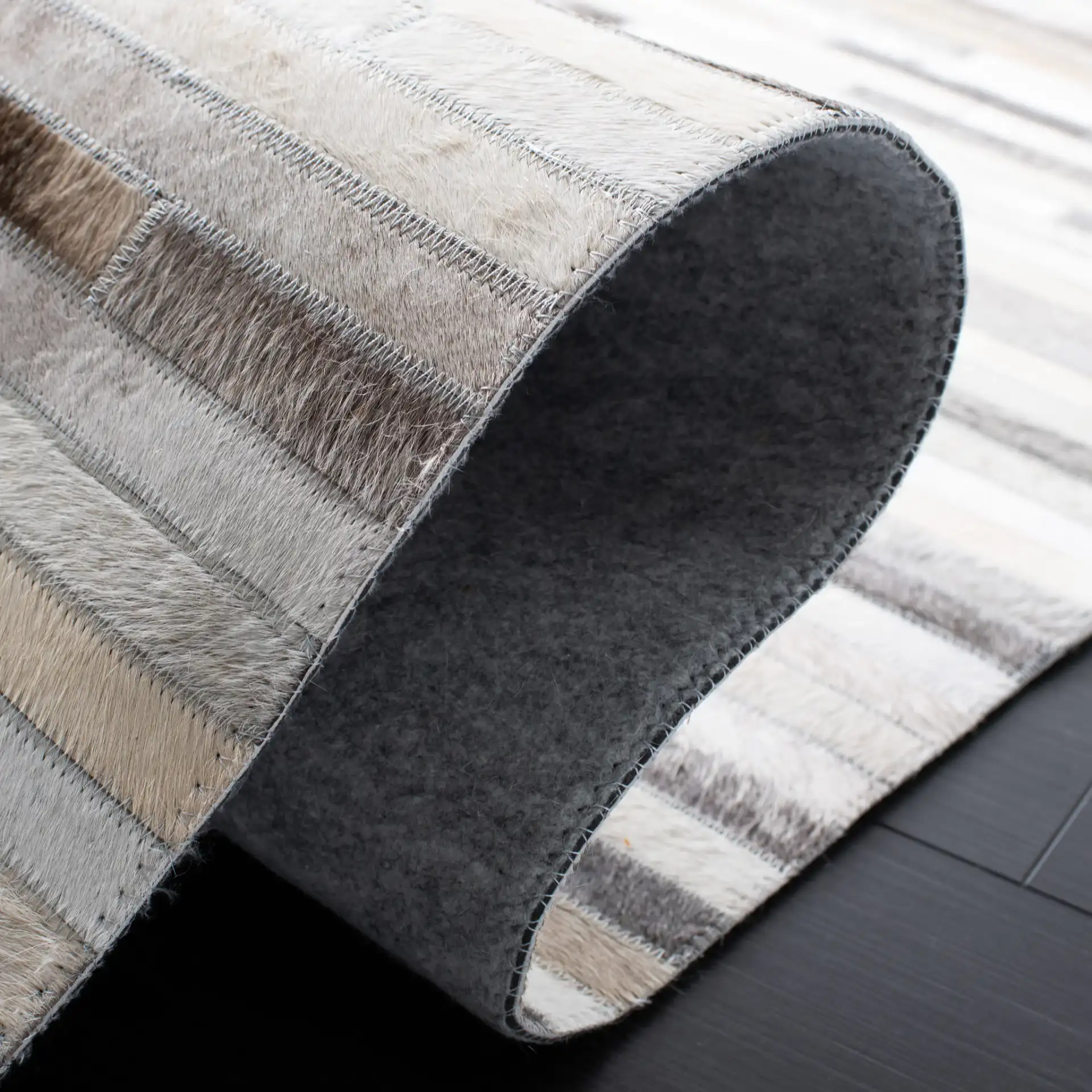 Studio Leather Brick Patchwork Hand-Woven Rug in Ivory / Gray in a styled room
