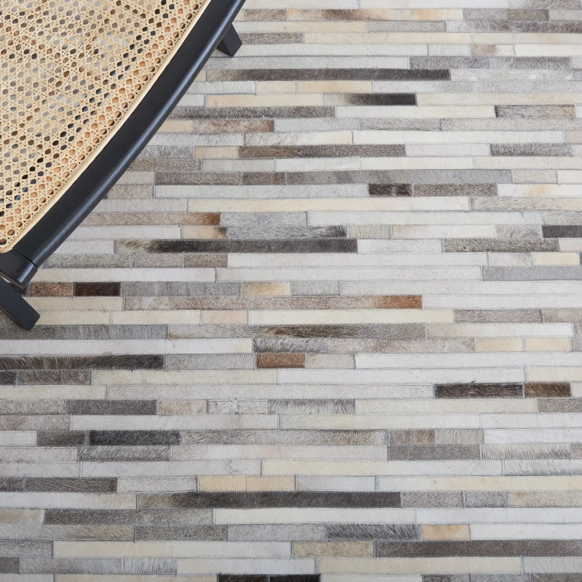 Studio Leather Brick Patchwork Hand-Woven Rug in Ivory / Gray in a styled room