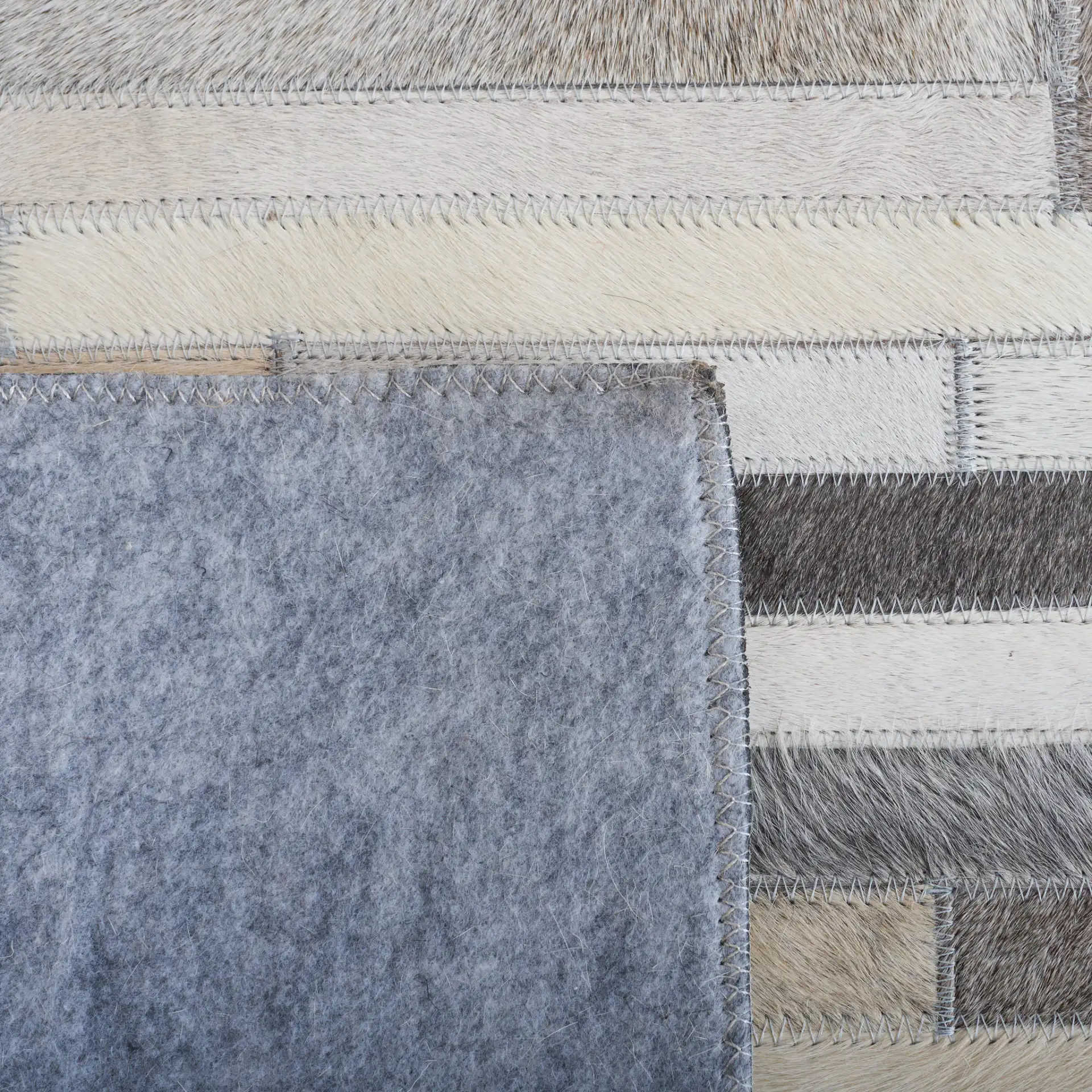 Studio Leather Brick Patchwork Hand-Woven Rug in Ivory / Gray in a styled room
