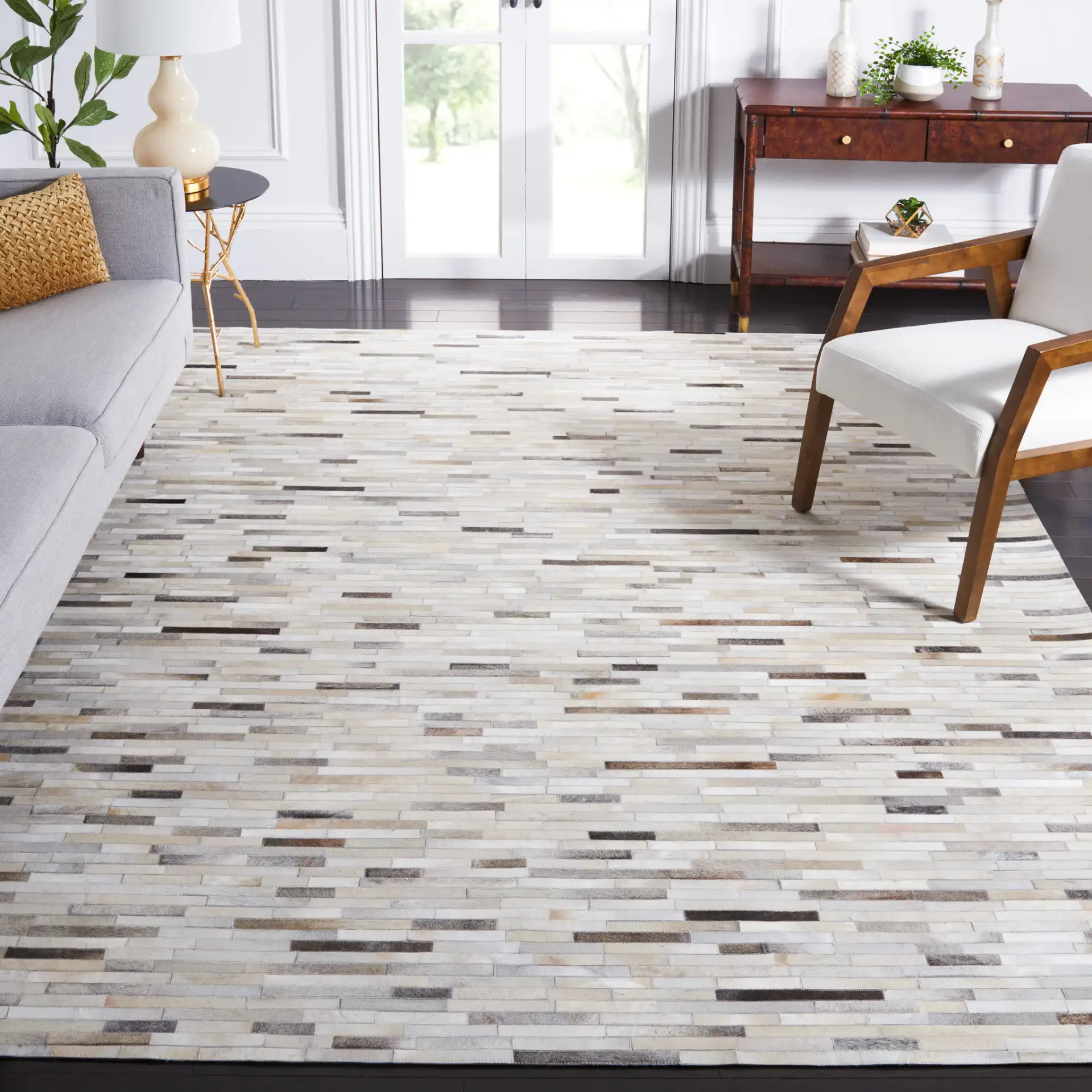 Studio Leather Brick Patchwork Hand-Woven Rug in Ivory / Gray in a styled room