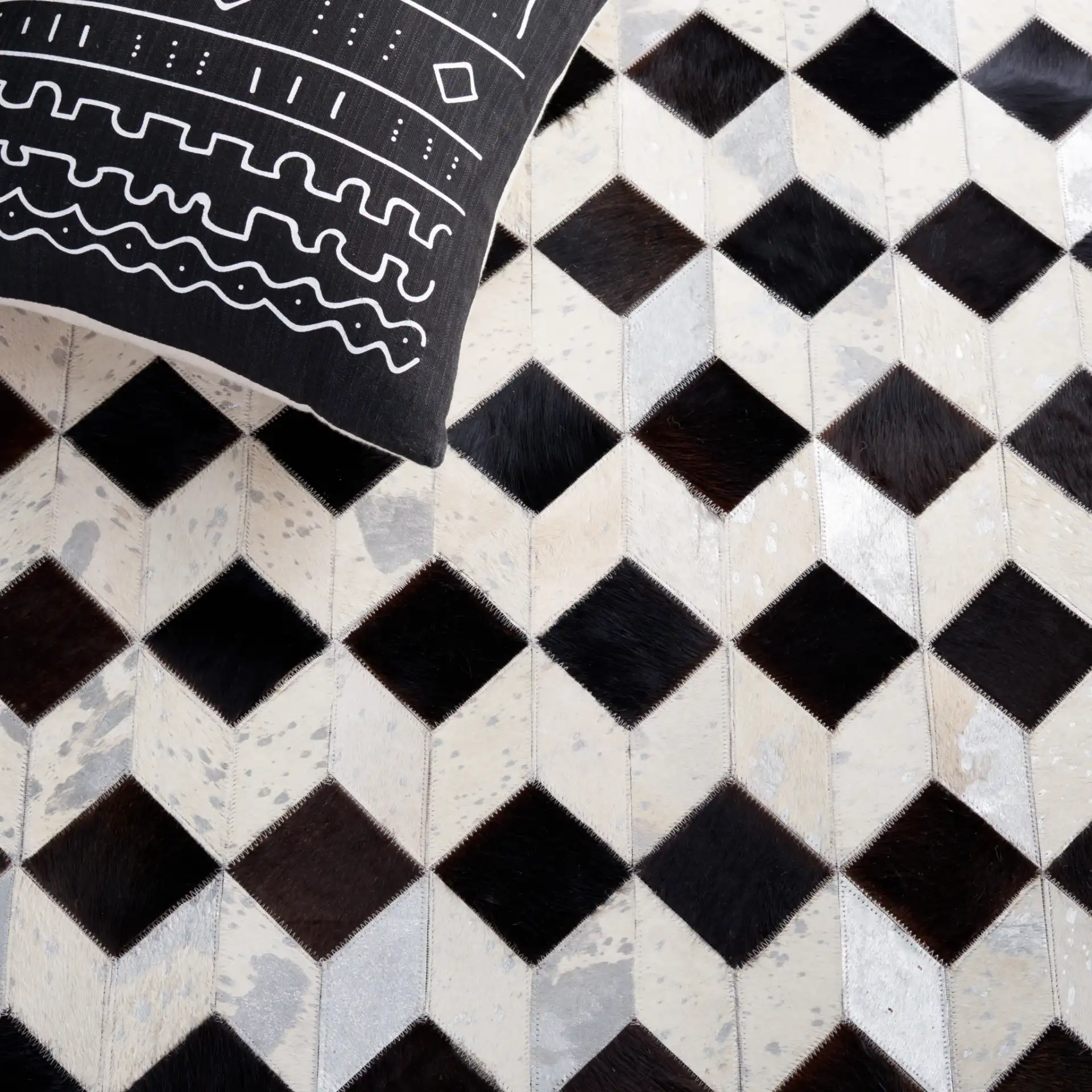Studio Leather Cube Patchwork Hand-Woven Rug in Beige / Black in a styled room