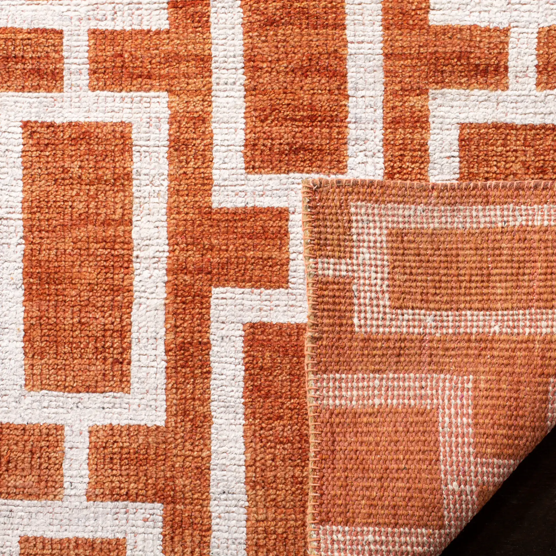Stone Wash Interlocking Rectangles Hand-Knotted Rug in Rust in a styled room