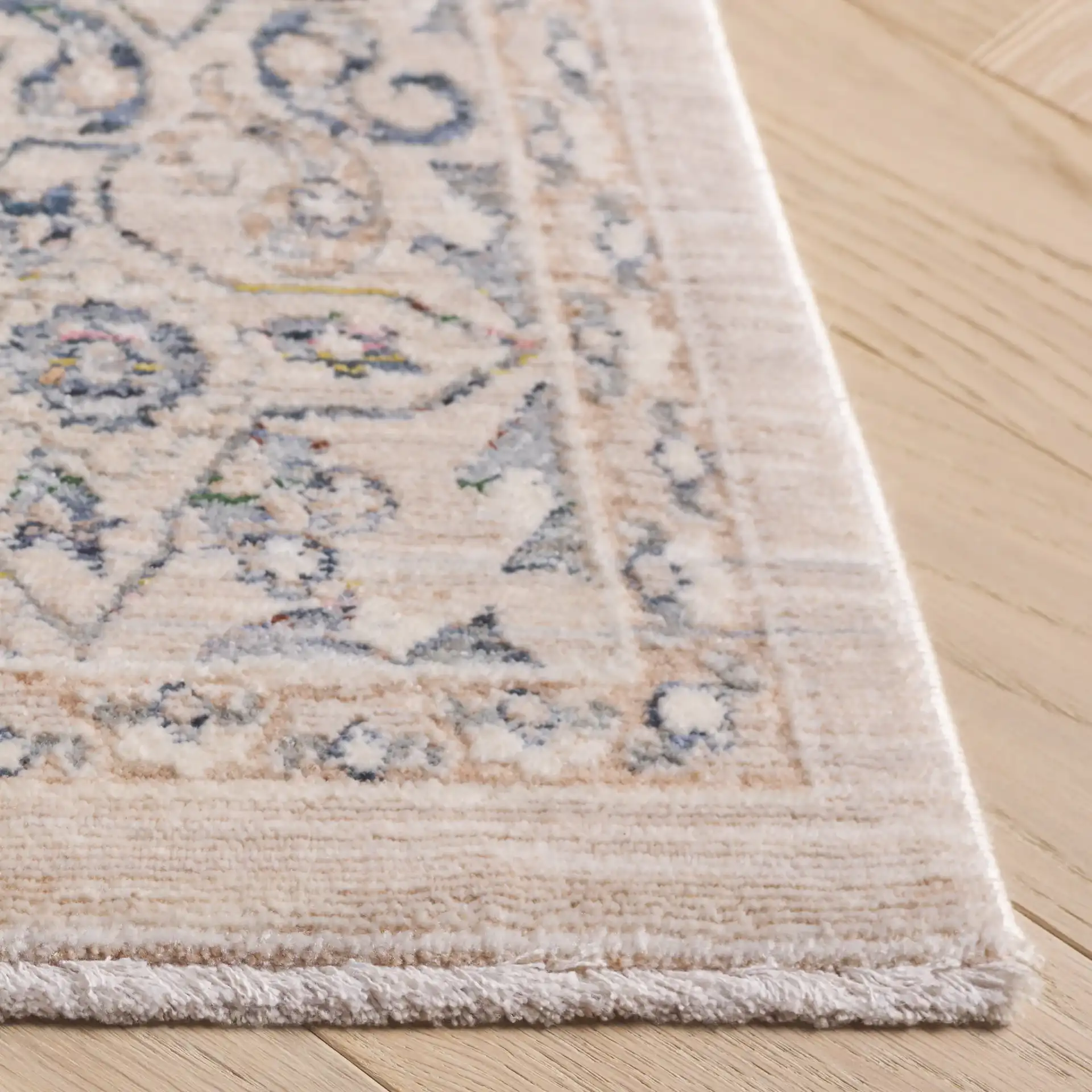 Sutton Floral Bordered Rug in Beige / Navy in a styled room