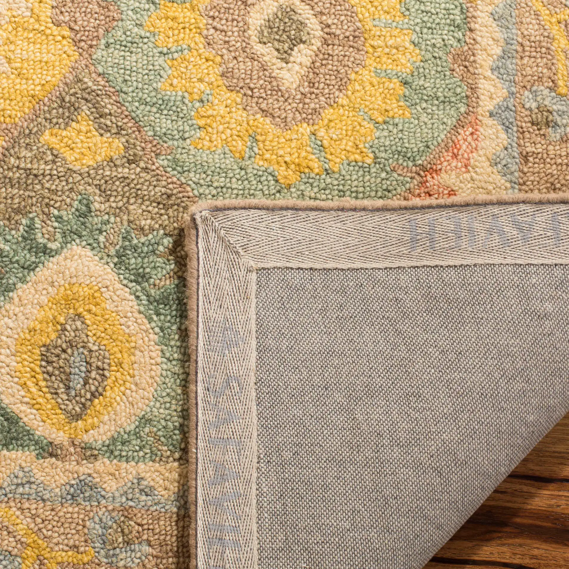 Suzani Bordered Ikat Diamond Hand-Hooked Wool Rug in Ivory / Multicolor in a styled room