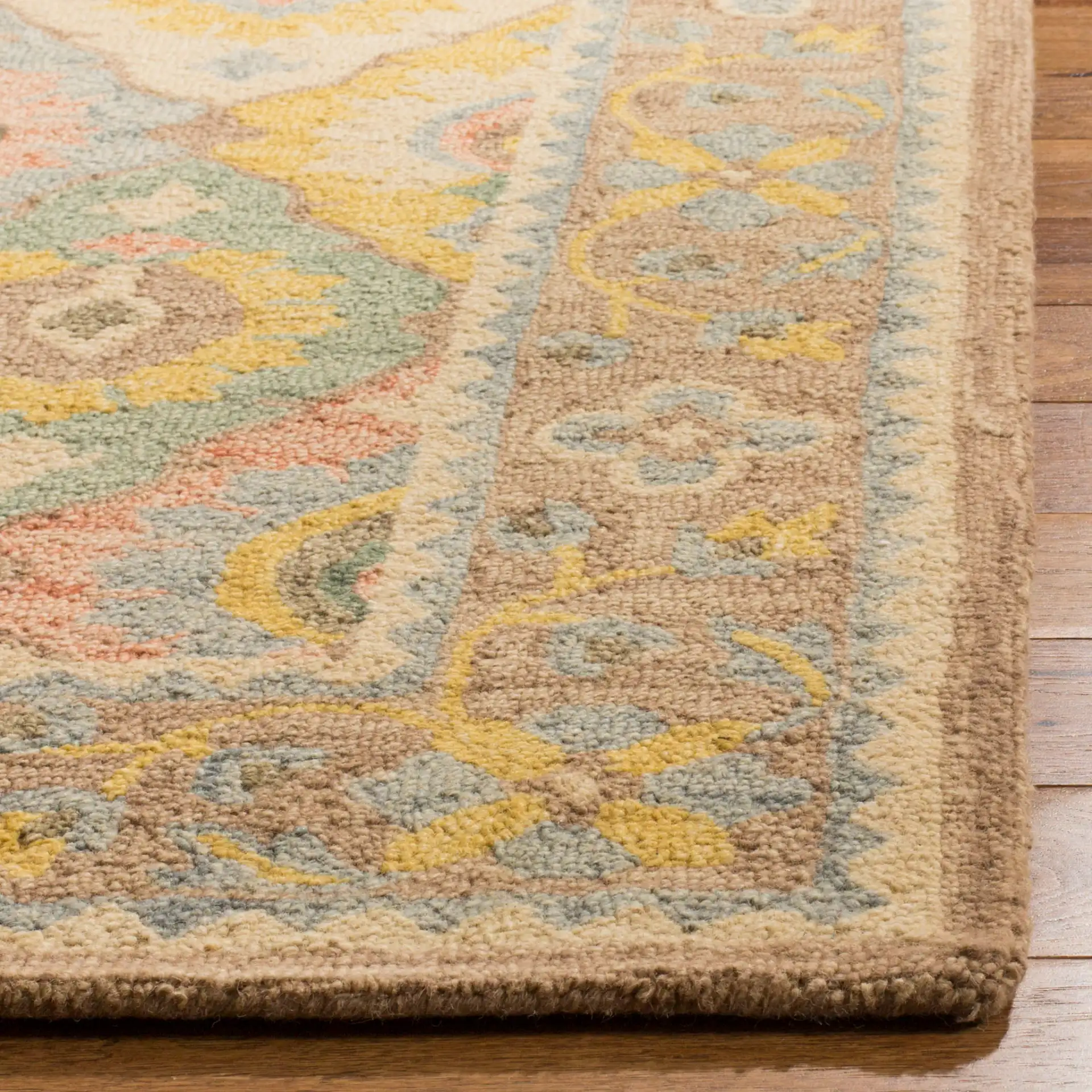 Suzani Bordered Ikat Diamond Hand-Hooked Wool Rug in Ivory / Multicolor in a styled room