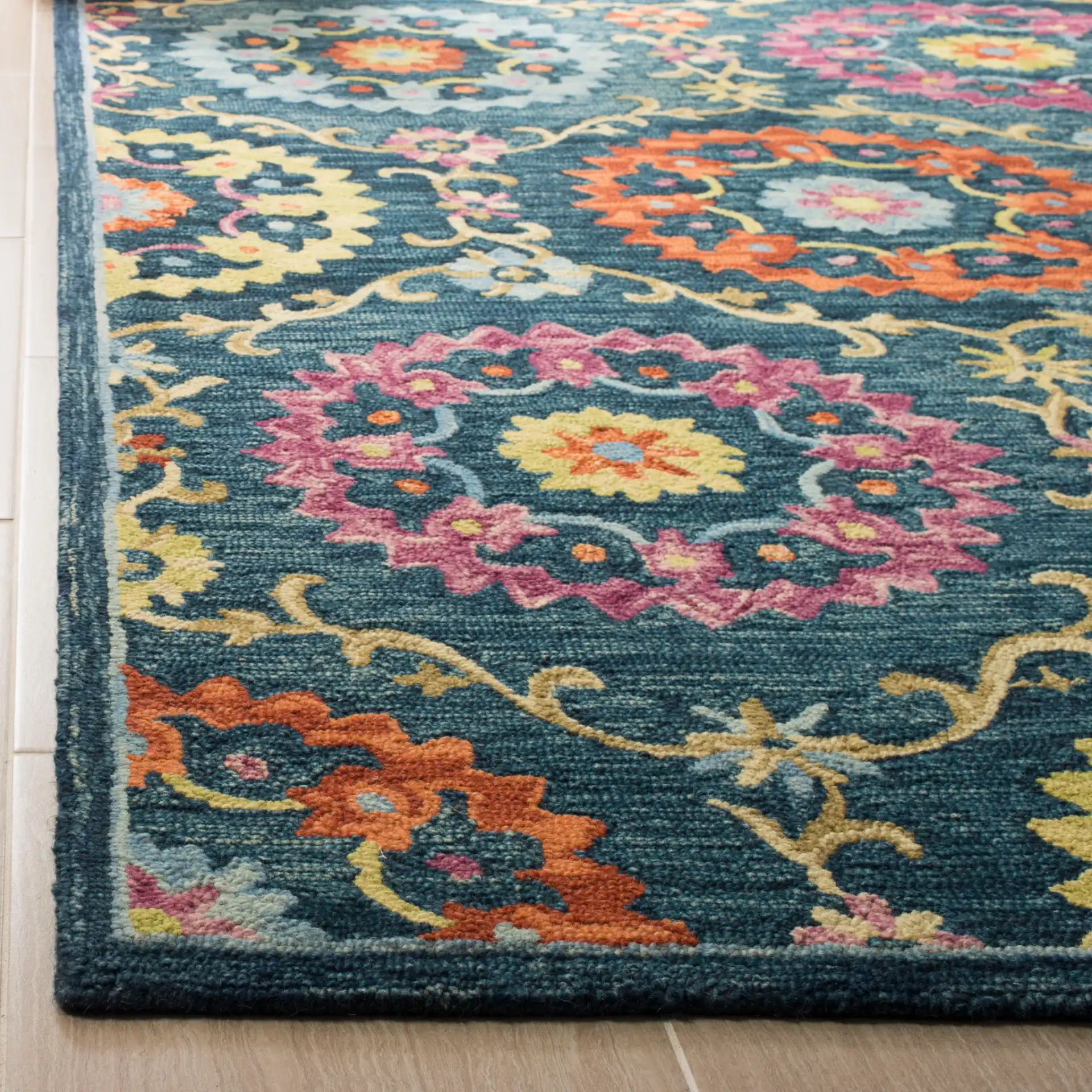 Suzani Rosette Trellis Hand-Hooked Wool Rug in Blue / Multicolor in a styled room