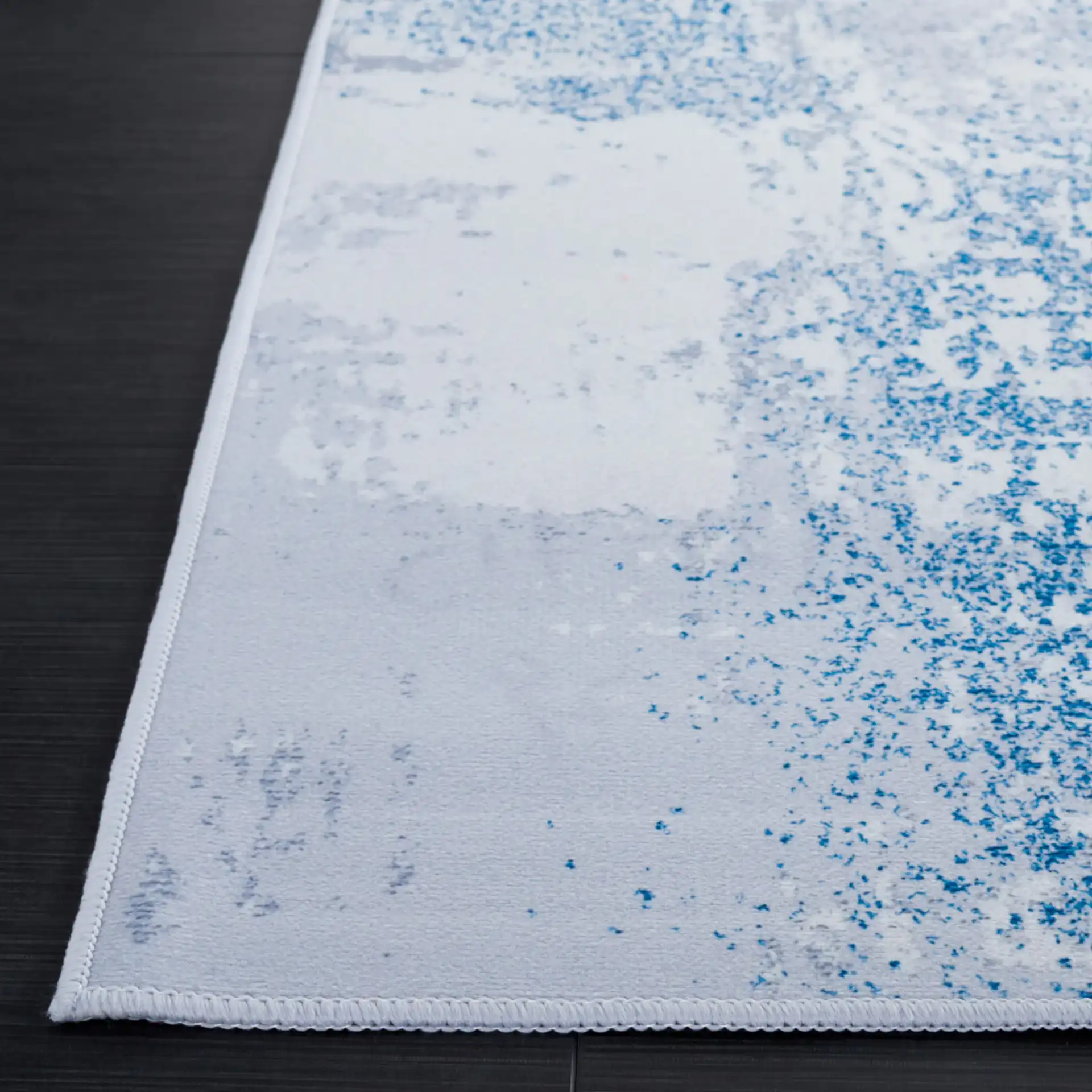 Tacoma Abstract Patchwork Washable Rug in Gray / Blue in a styled room