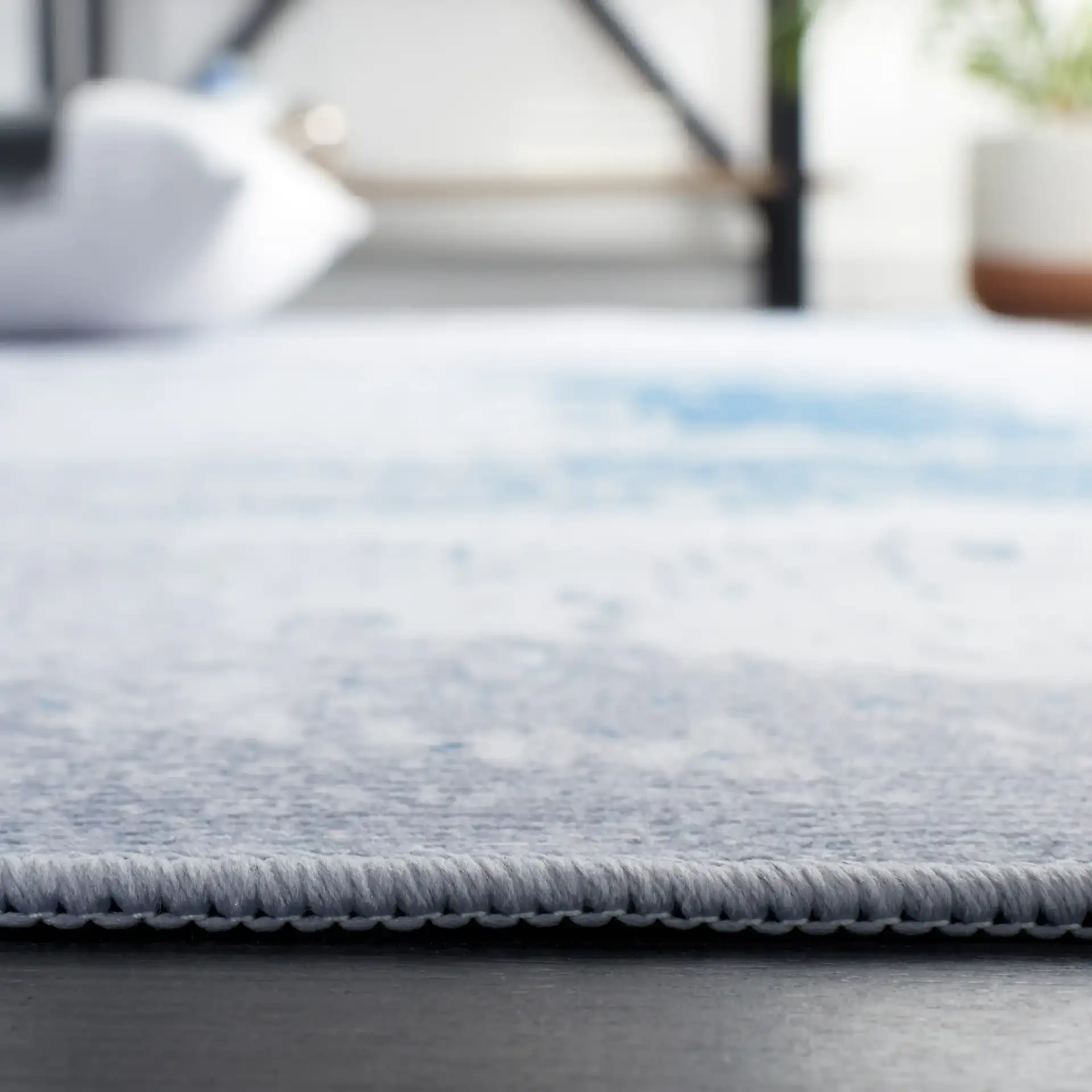 Tacoma Abstract Patchwork Washable Rug in Gray / Blue in a styled room