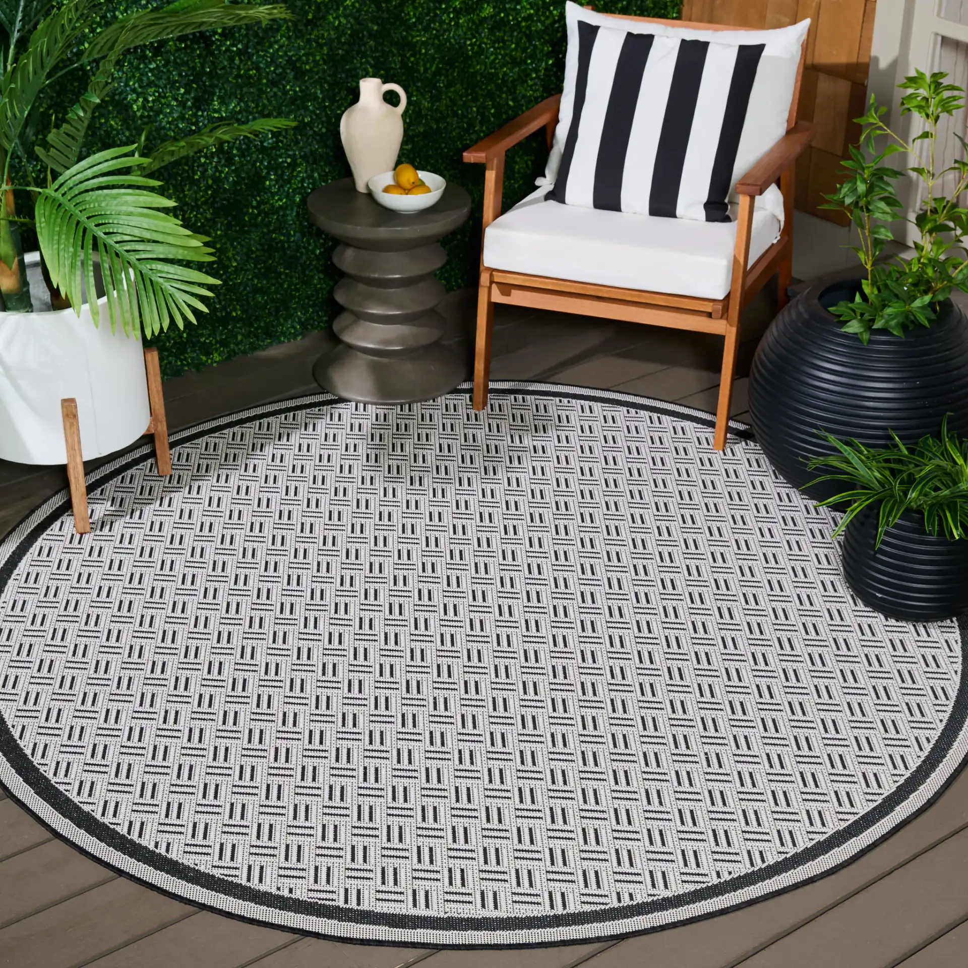 Terrace Basketweave Border Outdoor Rug in Black / White in a styled room