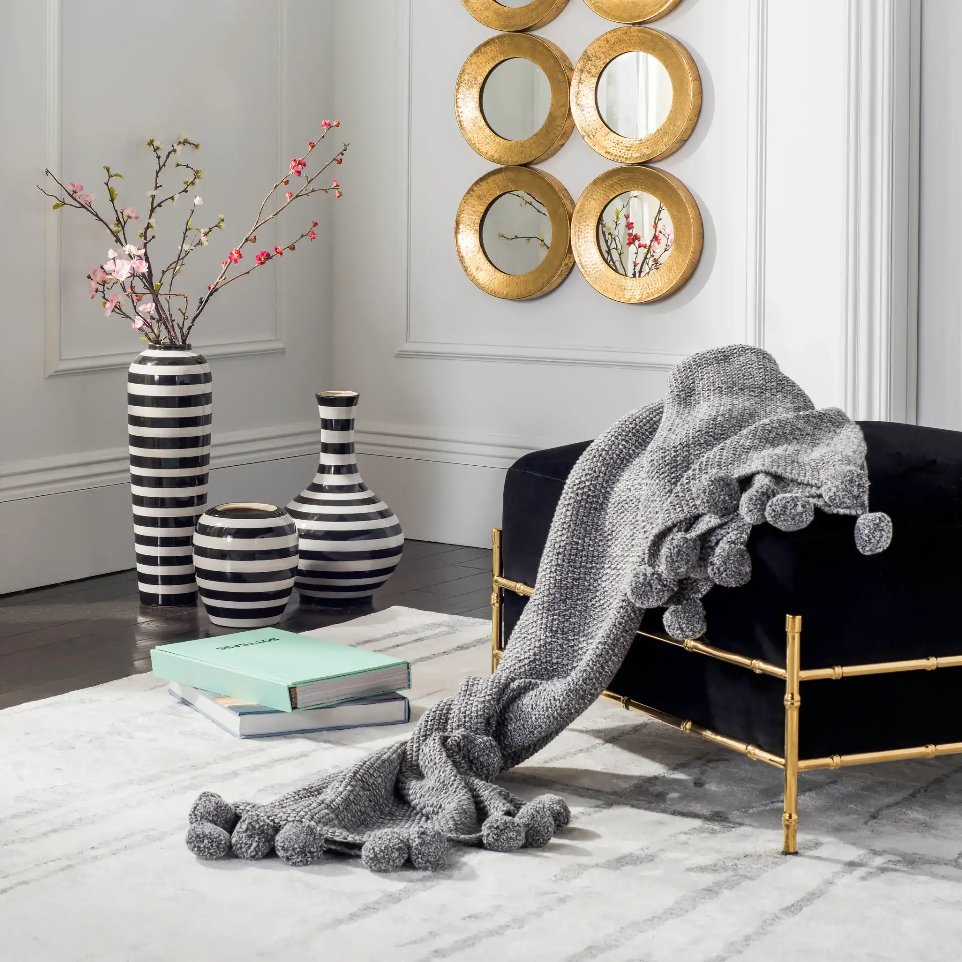 Pom Pom Knit Throw in Dark Gray / Natural in a styled room