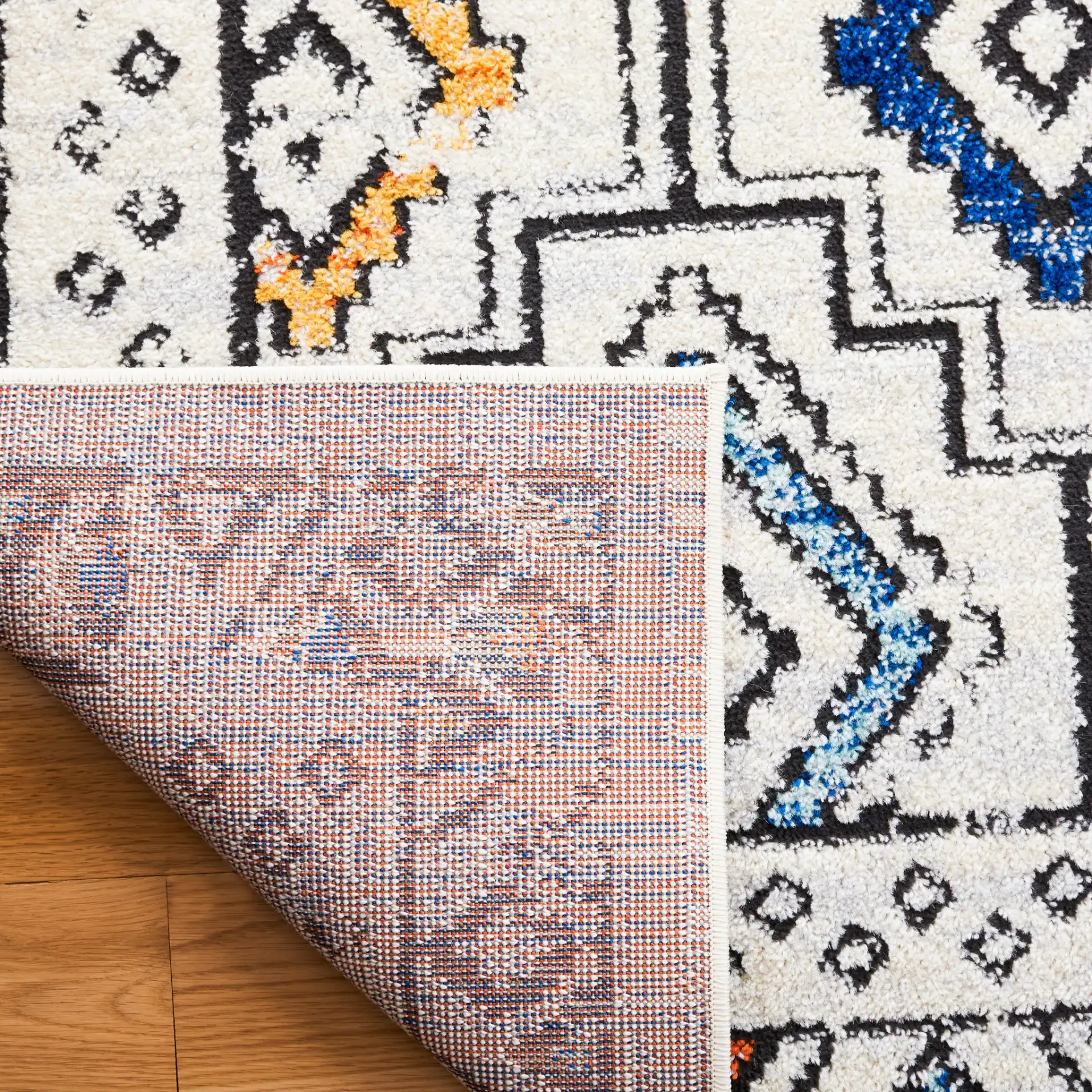 Tulum Bordered Stepped Diamond Rug in Ivory Gray / Blue Rust in a styled room