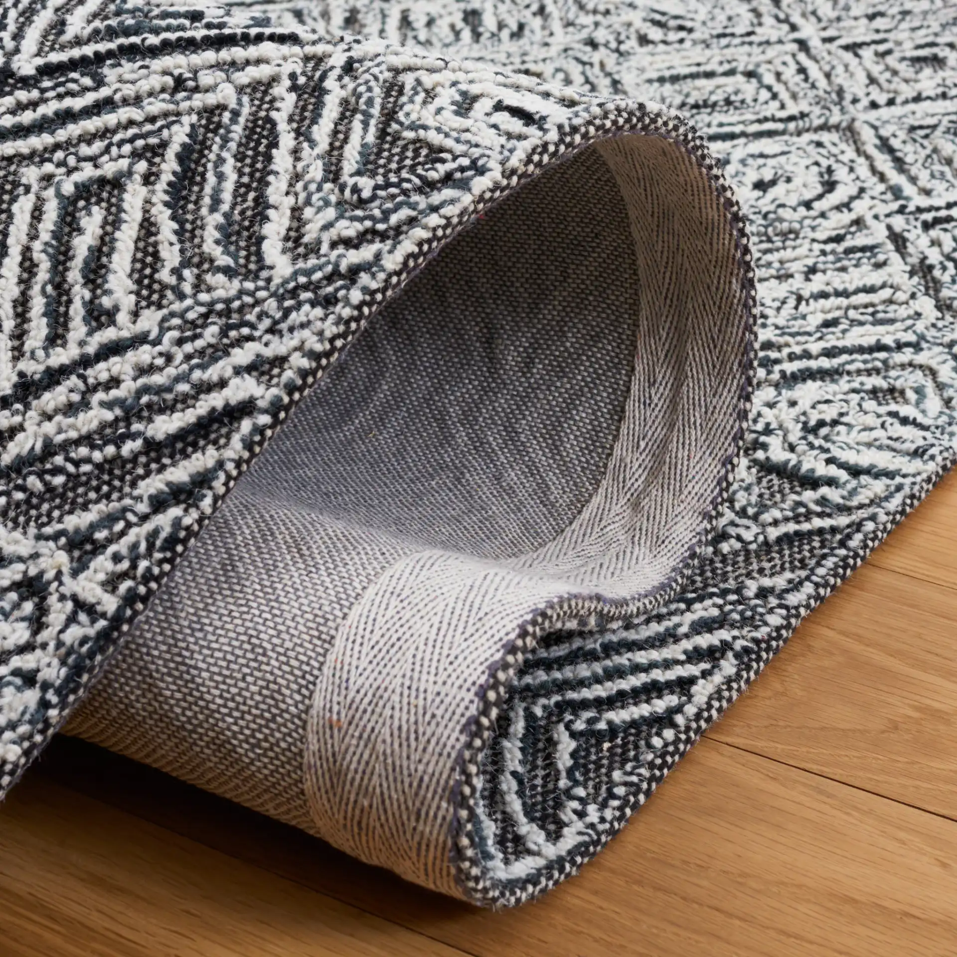 Textural Textual Nested Diamond Hand-Tufted Wool Rug in Black / Ivory in a styled room