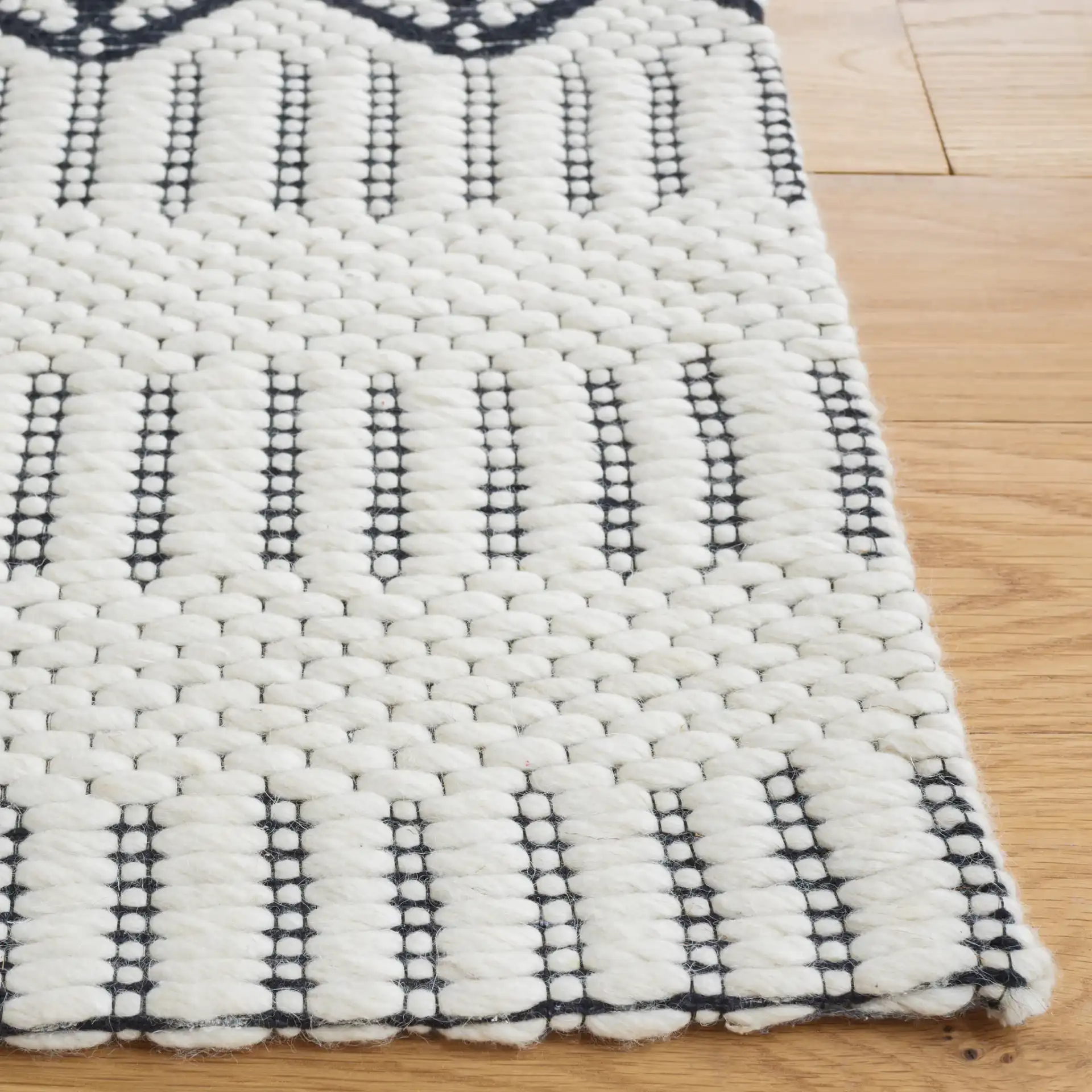 Vermont Stacked Diamond Trellis Hand-Woven Wool Rug in Ivory / Black in a styled room