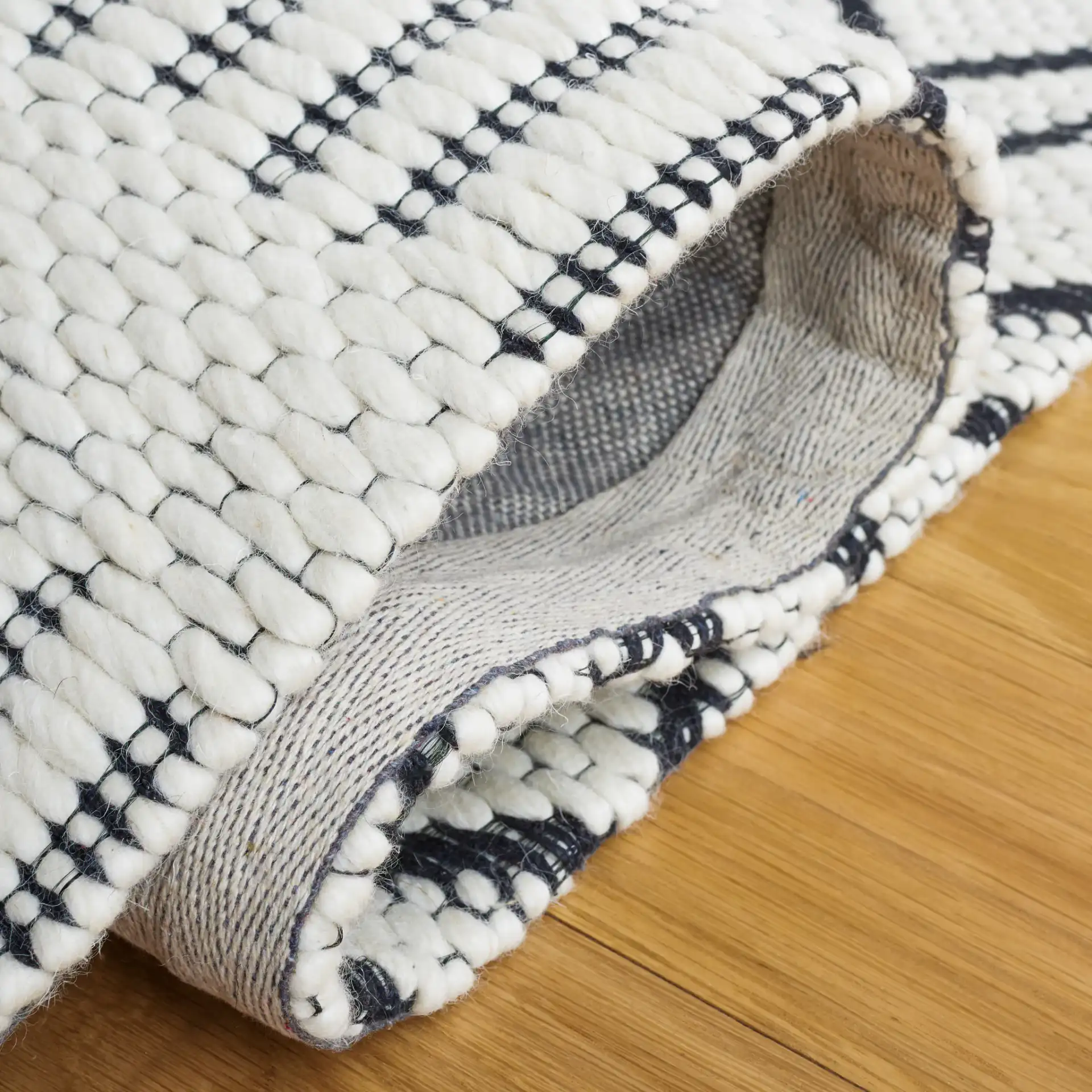 Vermont Stacked Diamond Trellis Hand-Woven Wool Rug in Ivory / Black in a styled room