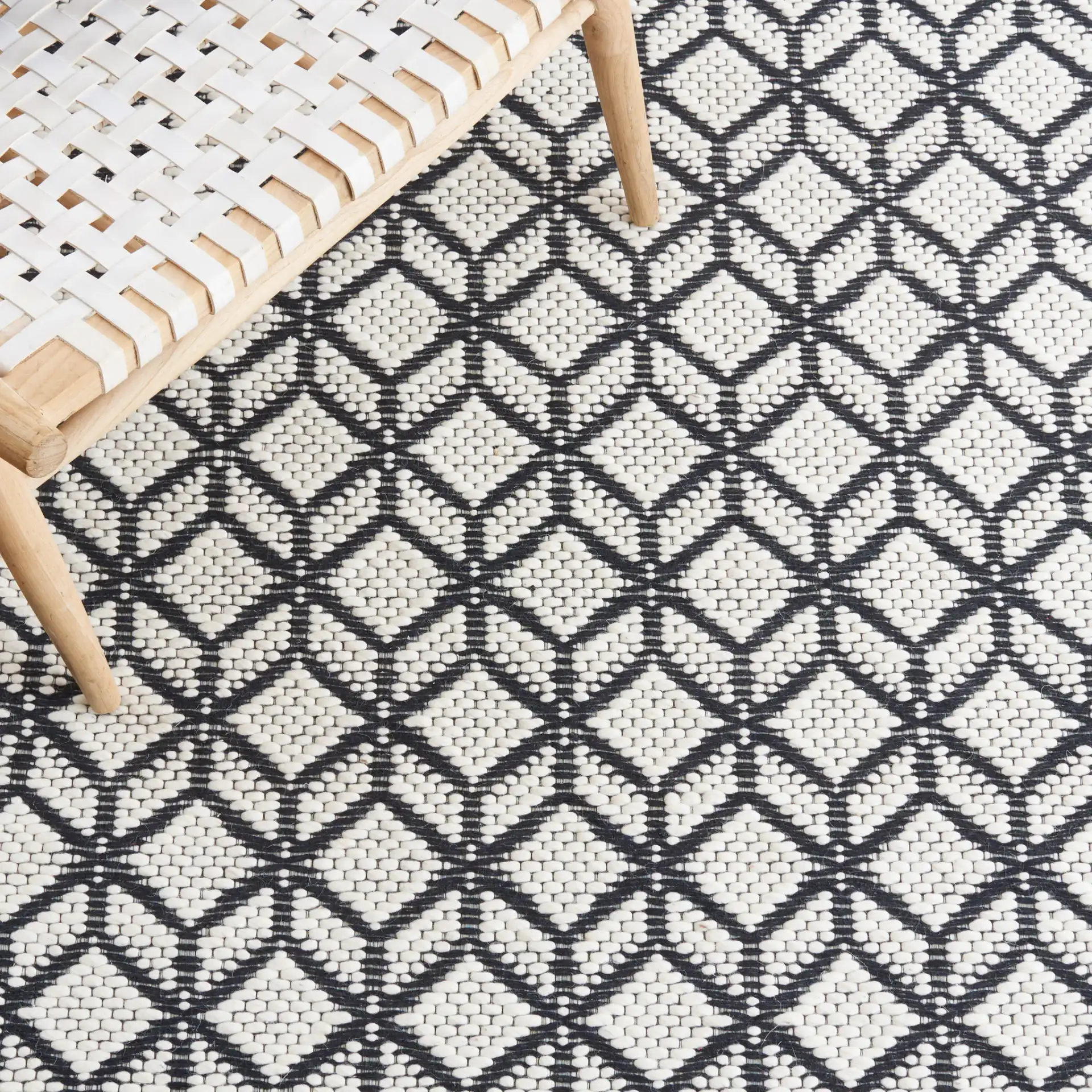 Vermont Stacked Diamond Trellis Hand-Woven Wool Rug in Ivory / Black in a styled room