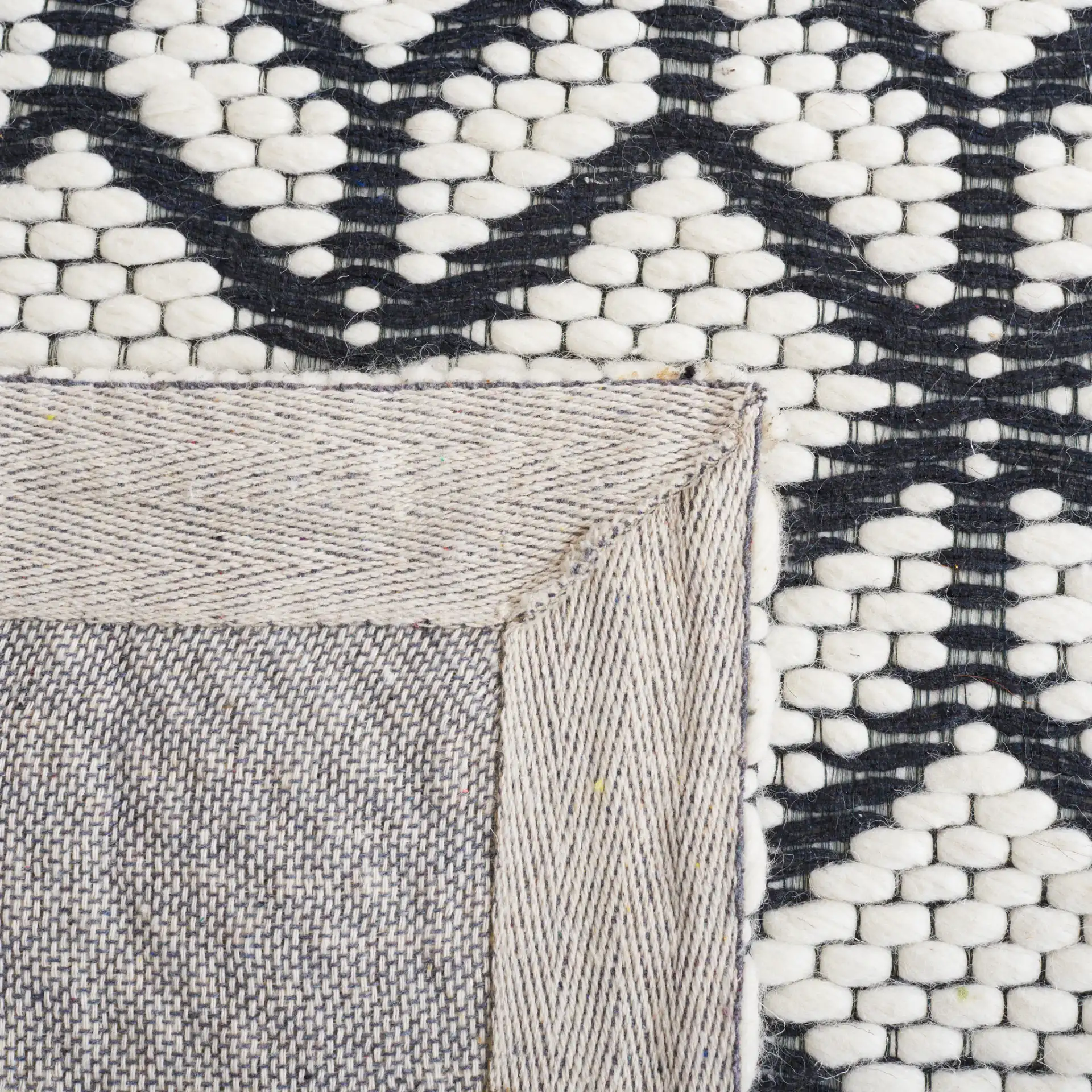 Vermont Stacked Diamond Trellis Hand-Woven Wool Rug in Ivory / Black in a styled room