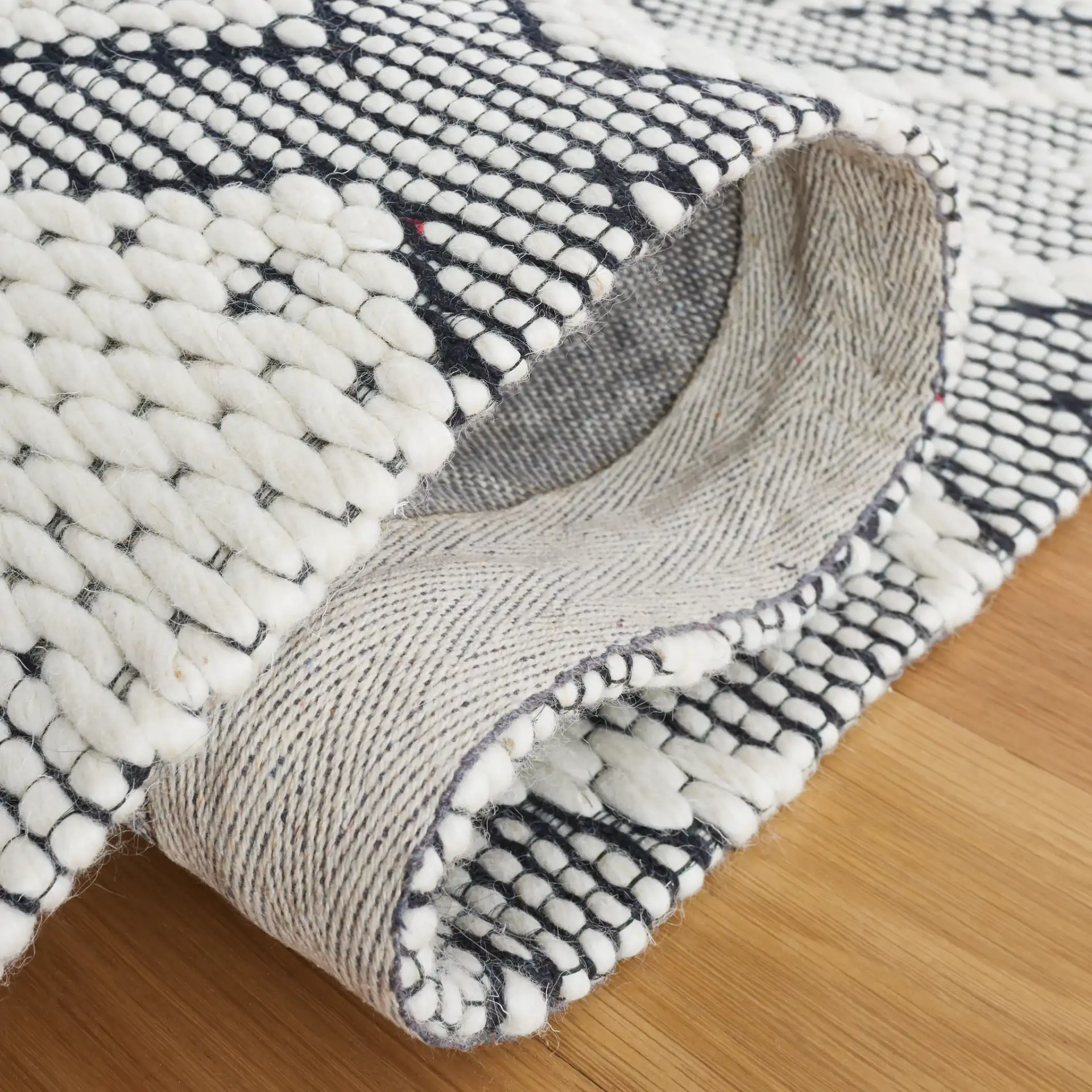 Vermont Concentric Diamond Band Hand-Woven Wool Rug in Ivory / Black in a styled room