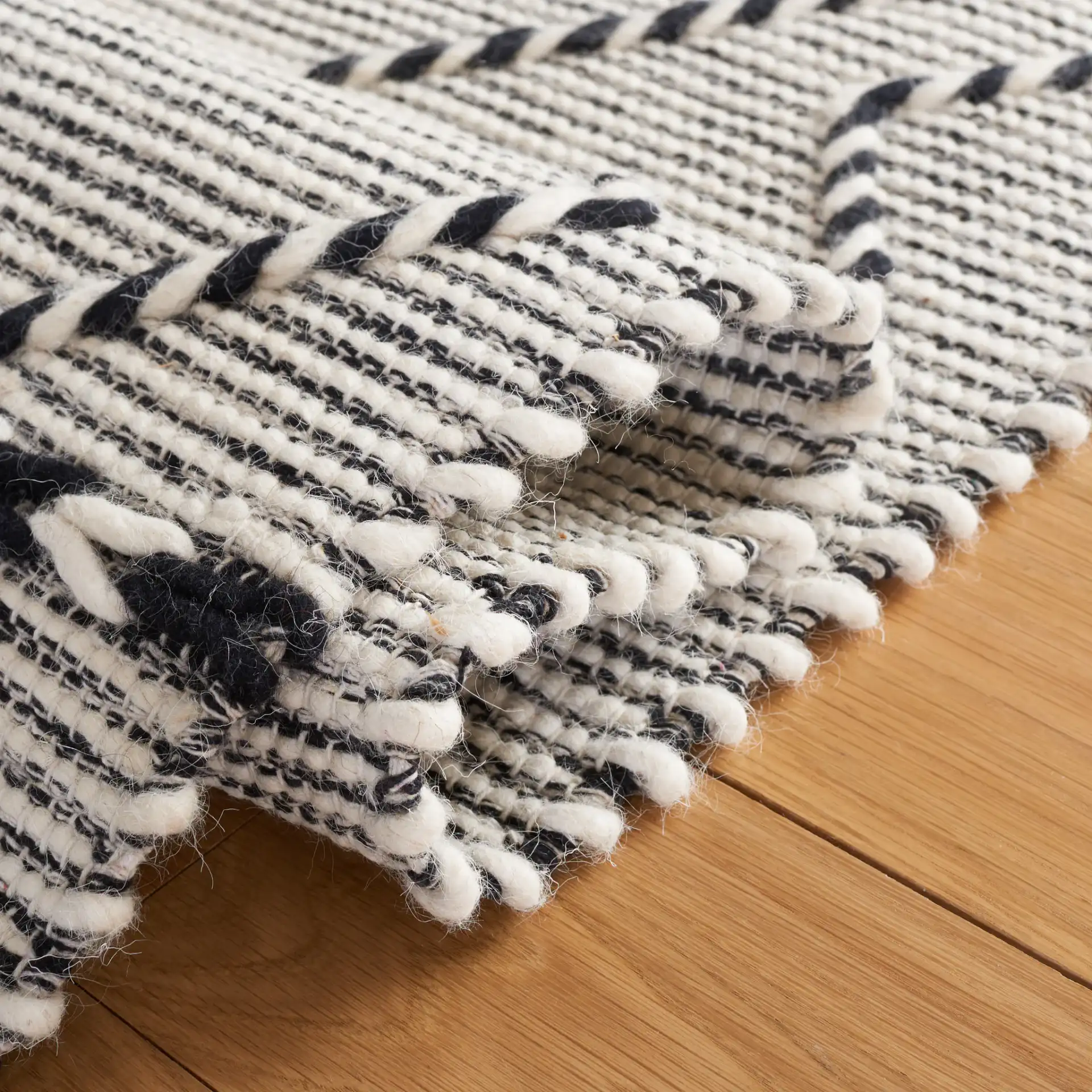 Vermont Large Diamond Hand-Woven Wool Rug in Ivory / Black in a styled room