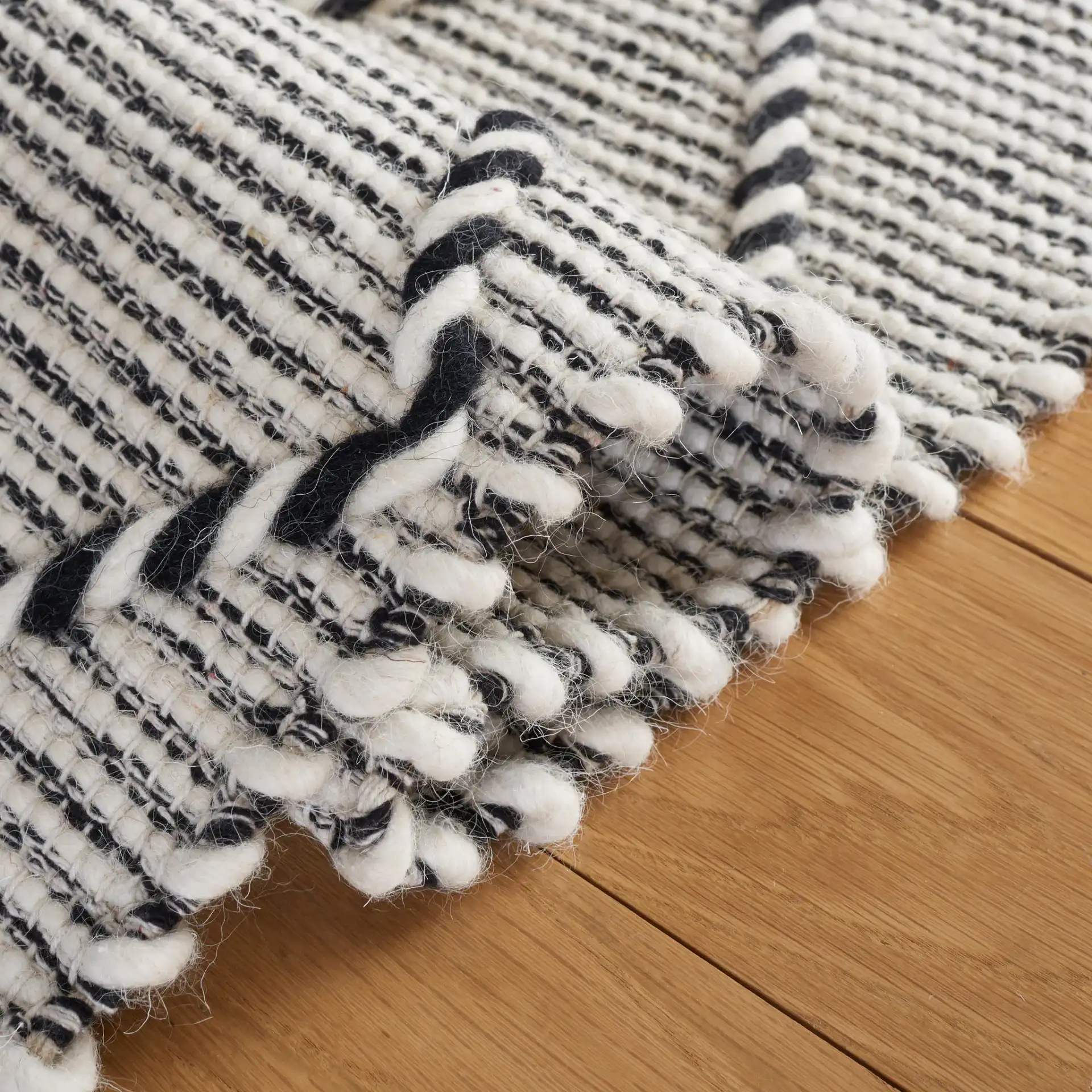 Vermont Thin Diamond Trellis Hand-Woven Wool Rug in Ivory / Black in a styled room