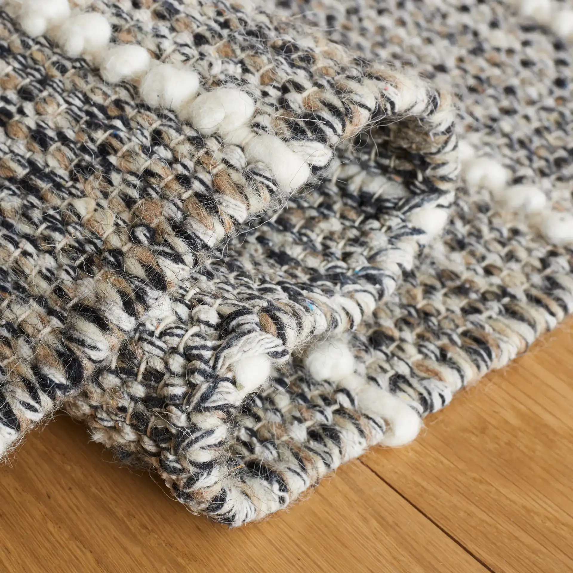 Vermont Striped Chevron Hand-Loomed Wool Rug in Black / Ivory in a styled room