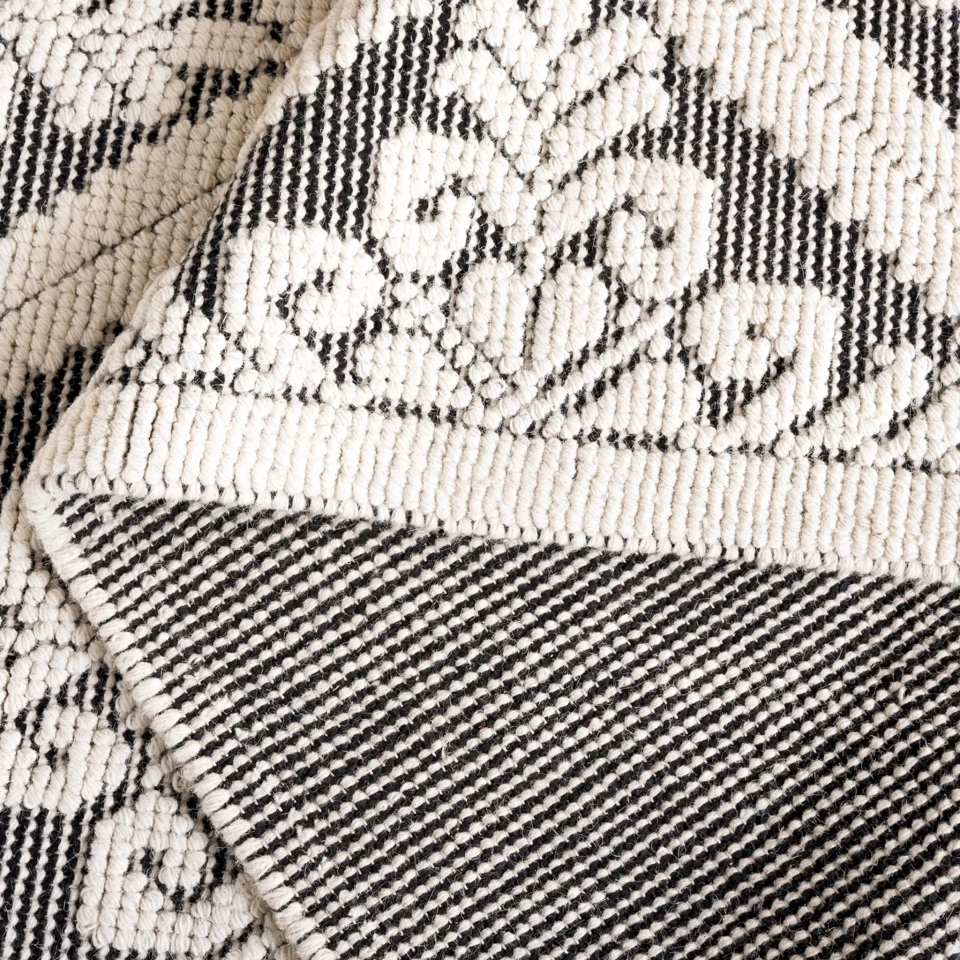 Vermont Floral Diamond Hand-Woven Wool Rug in Ivory / Black in a styled room