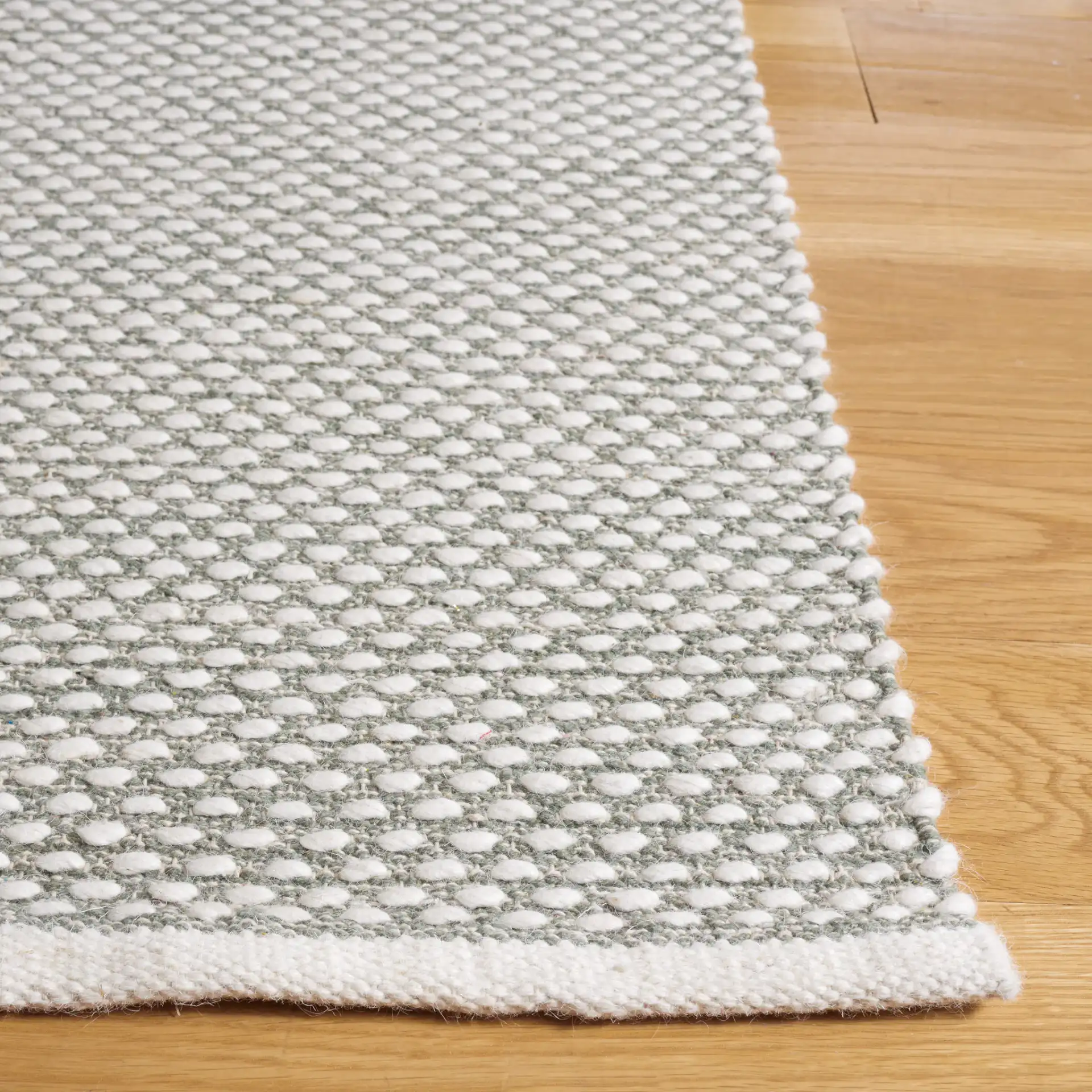 Vermont Textured Flatweave Wool Rug in Green in a styled room