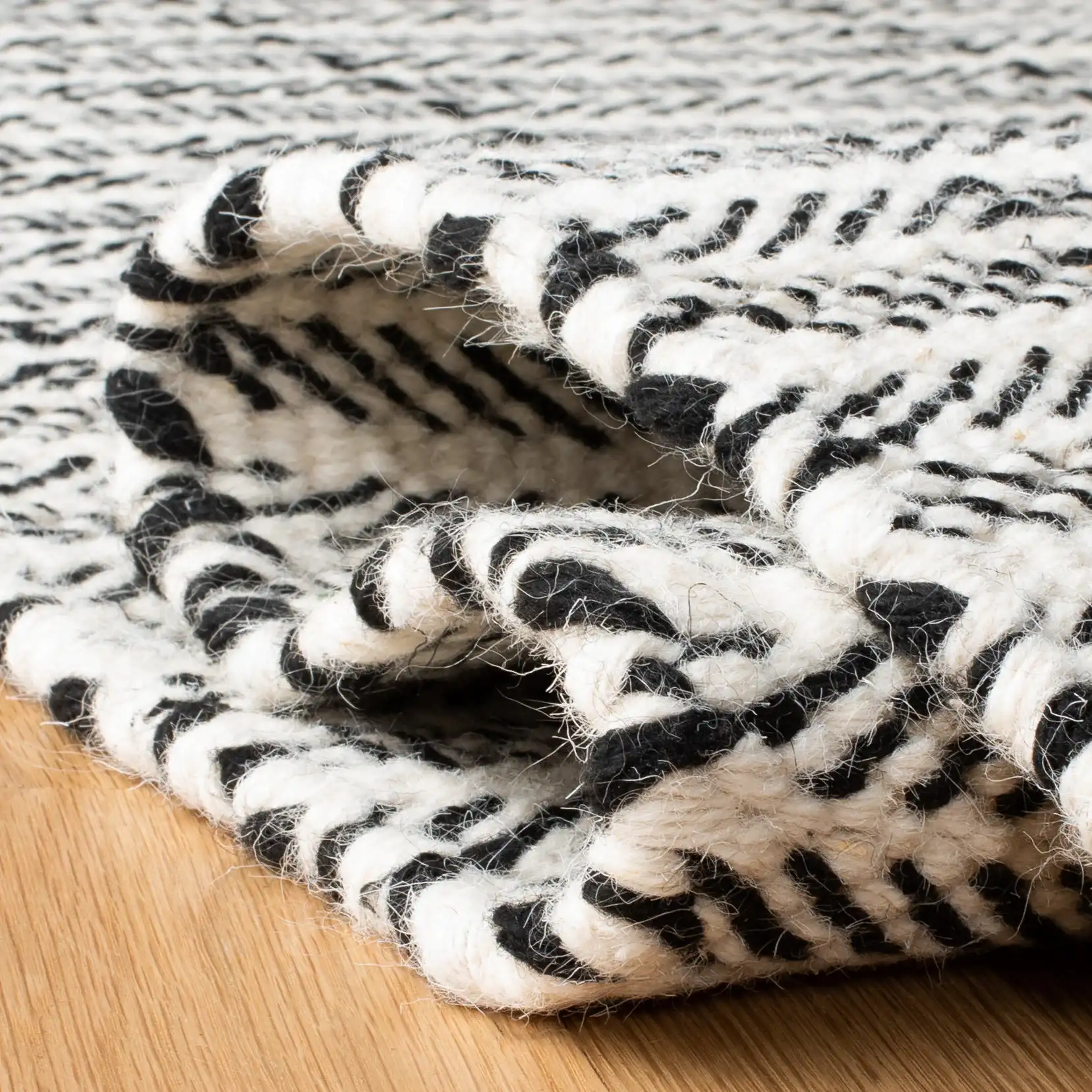 Vermont Chevron Hand-Tufted Wool Rug in Black / Ivory in a styled room
