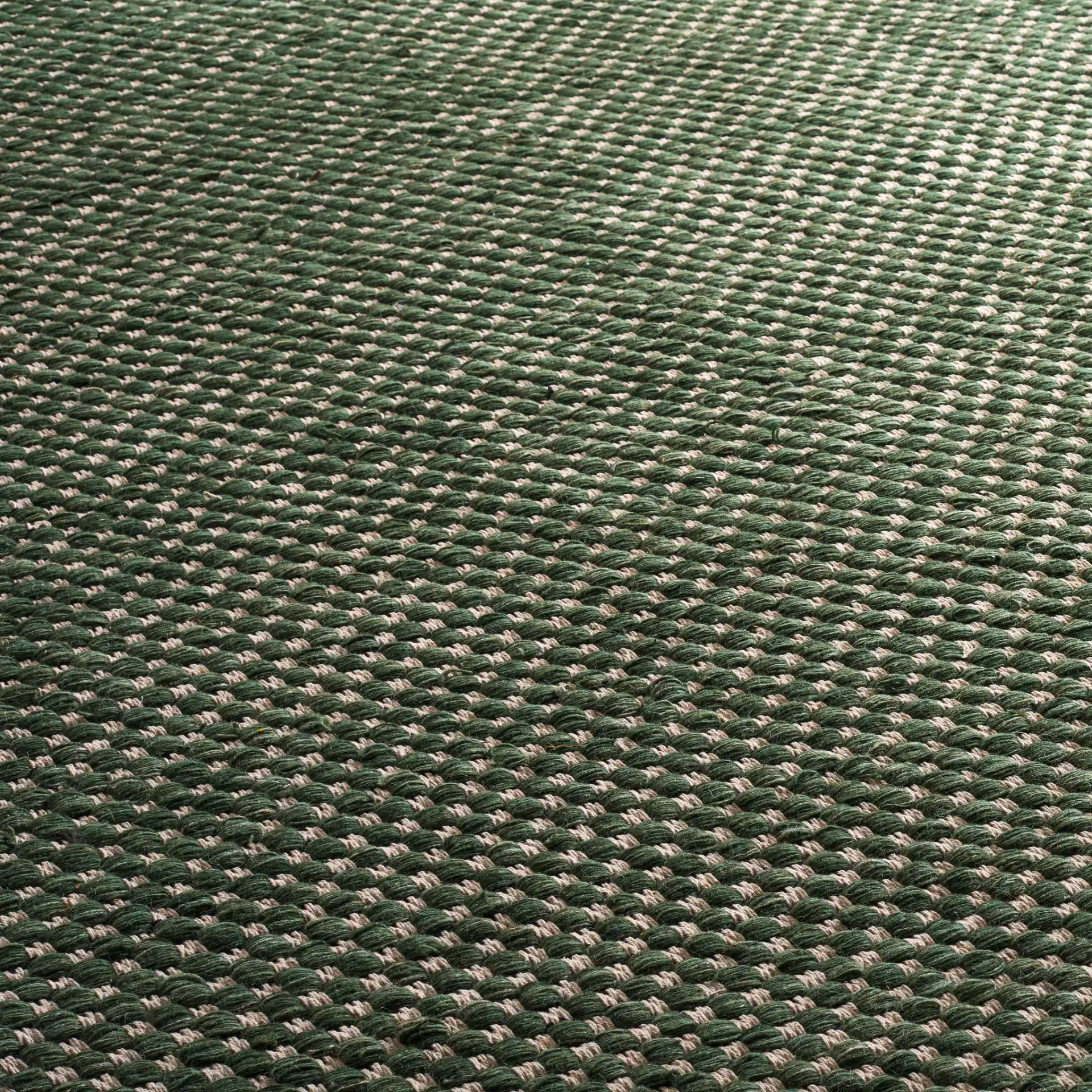 Vermont Pebbled Flatweave Wool Rug in Green / Ivory in a styled room