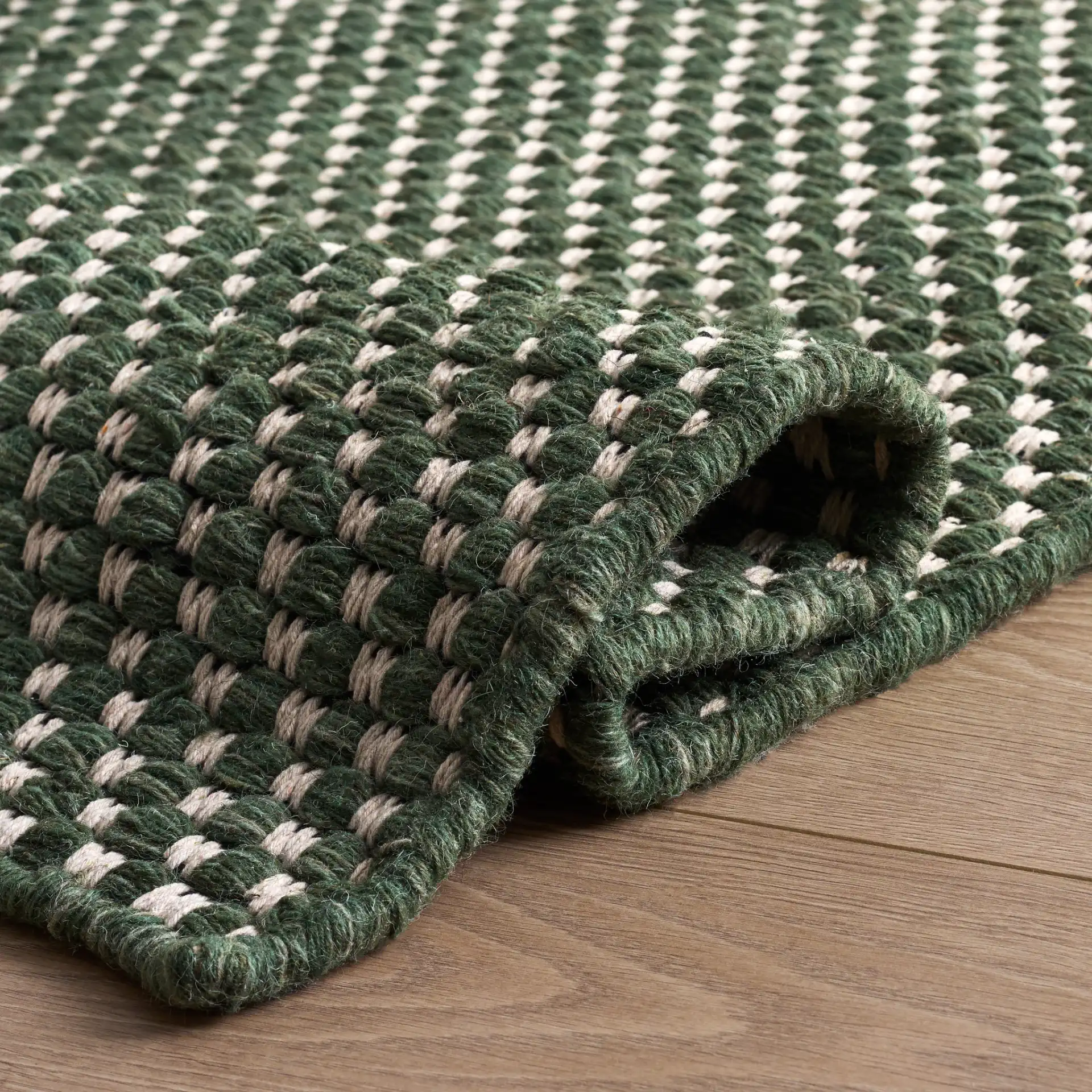Vermont Pebbled Flatweave Wool Rug in Green / Ivory in a styled room