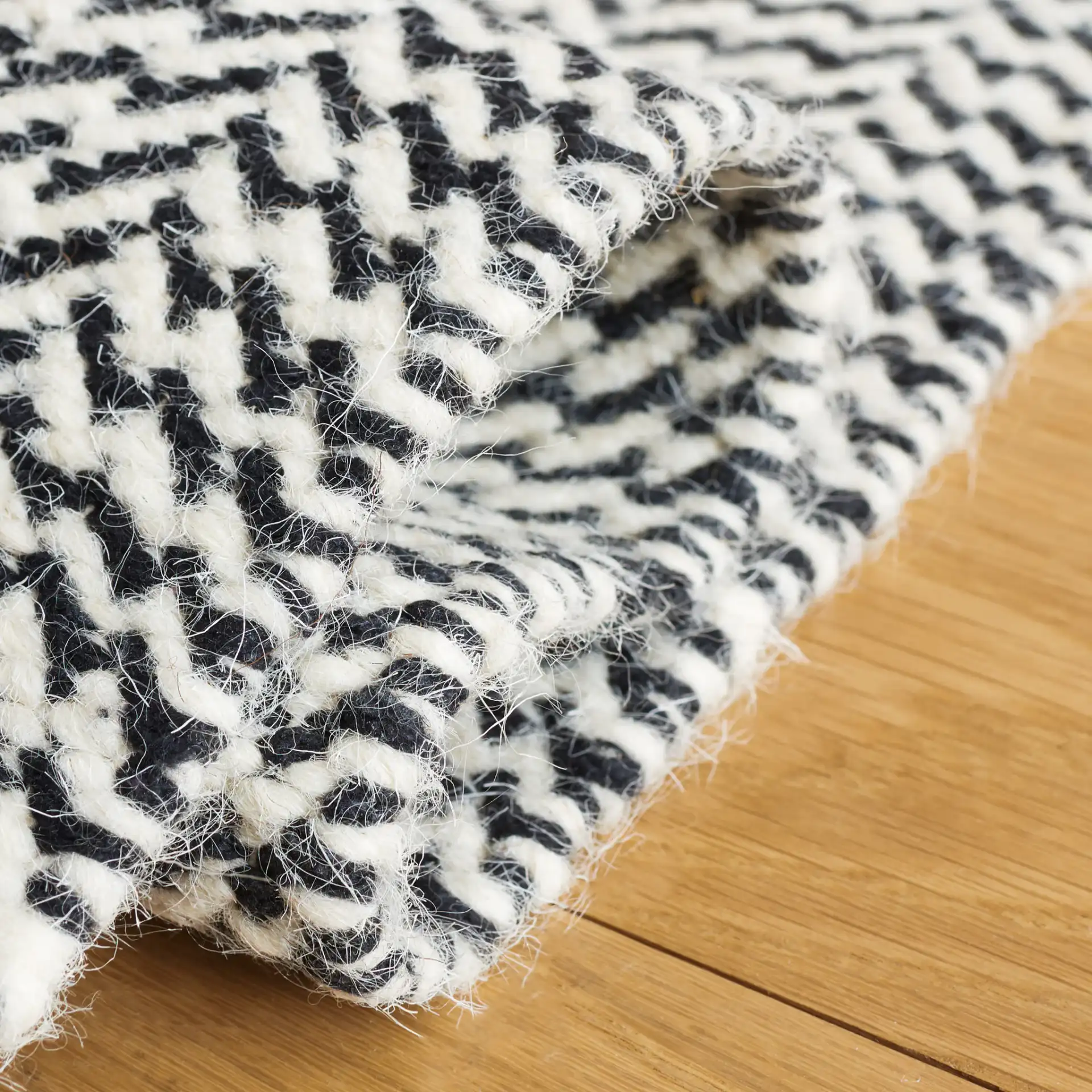 Vermont Chevron Hand-Woven Wool Rug in Black / Ivory in a styled room