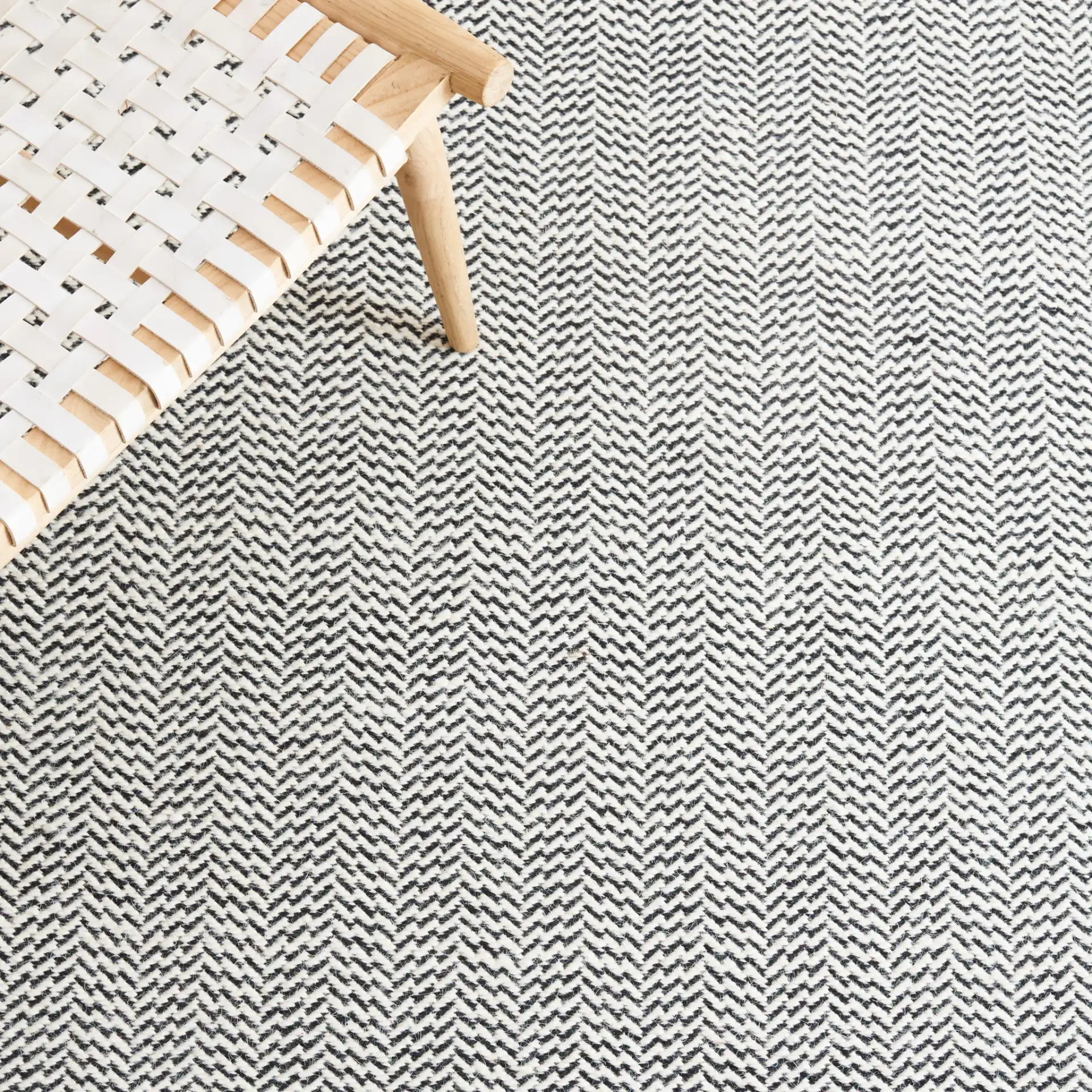 Vermont Chevron Hand-Woven Wool Rug in Black / Ivory in a styled room