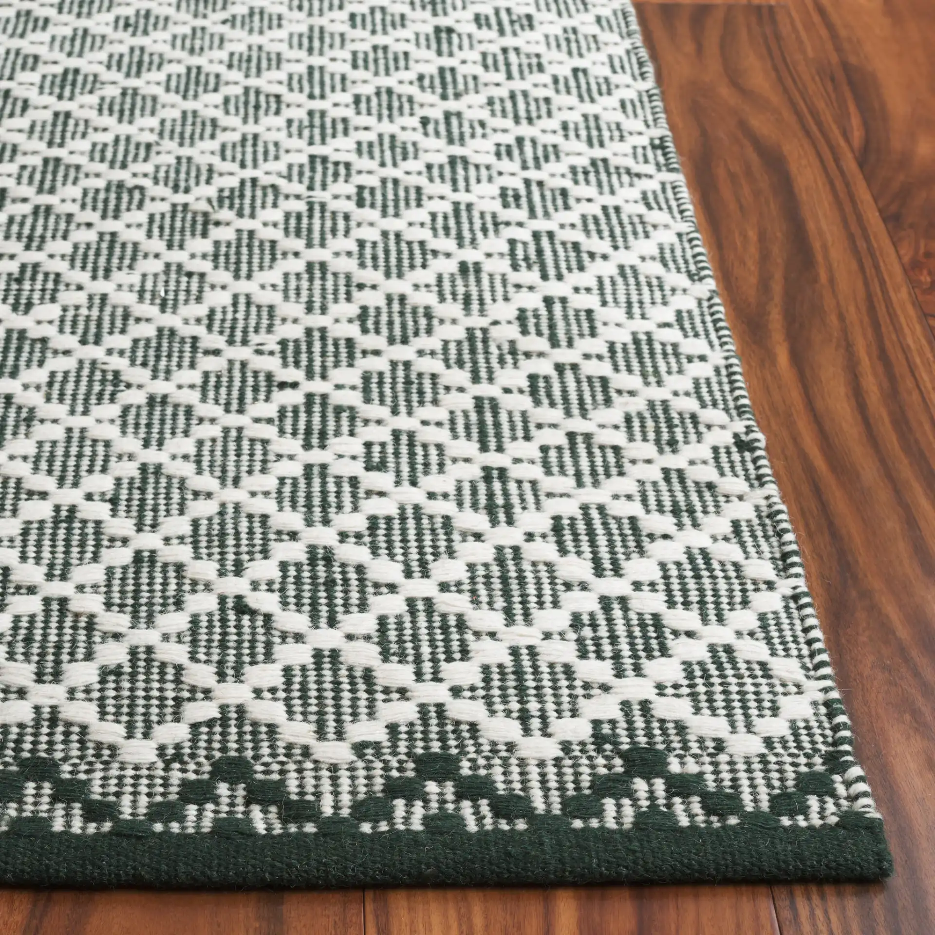 Vermont Micro Diamond Hand-Woven Wool Rug in Green / Ivory in a styled room