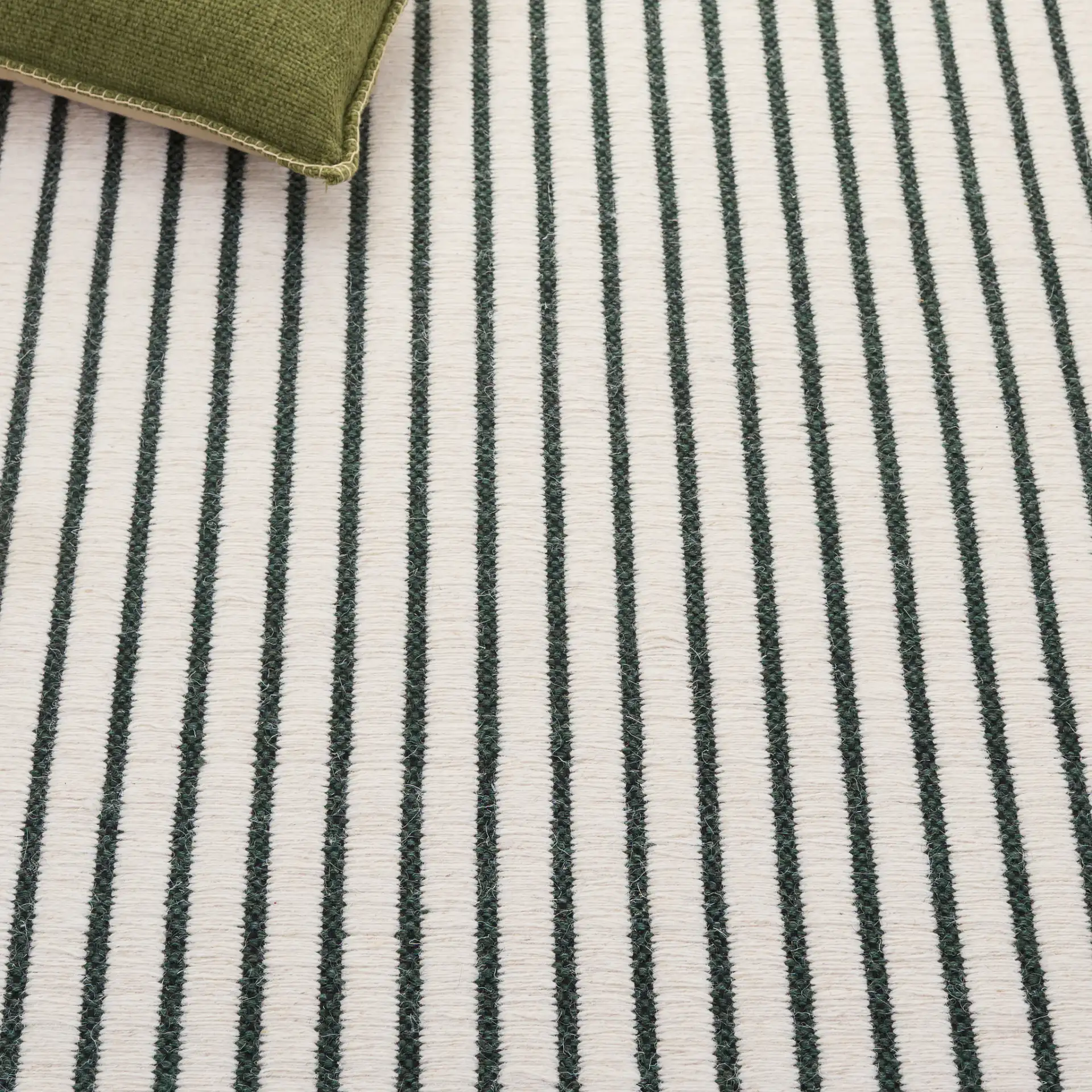 Vermont Pinstripe Hand-Woven Wool Rug in Dark Green / Ivory in a styled room