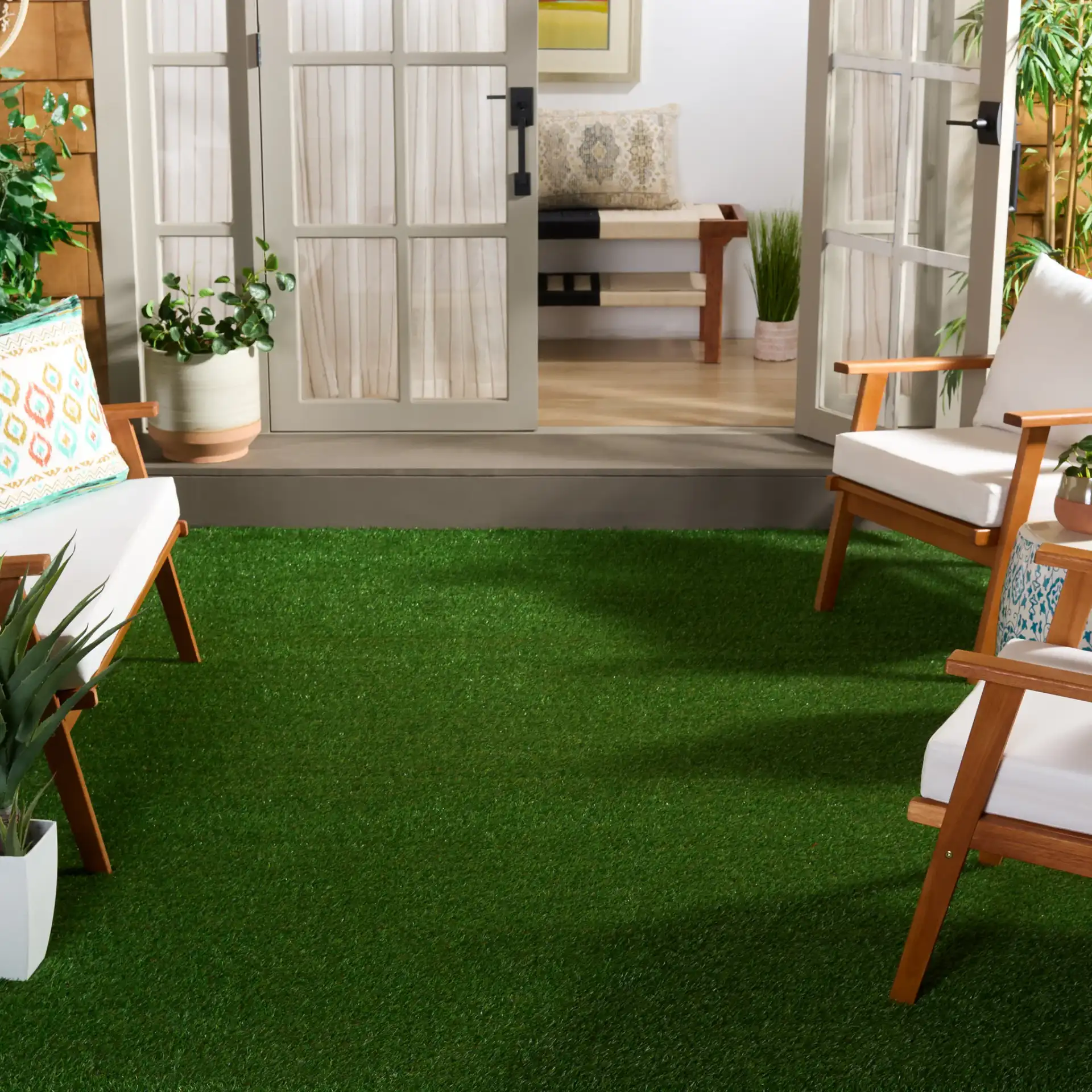 Turf Textured Solid Outdoor Rug in Natural / Green in a styled room